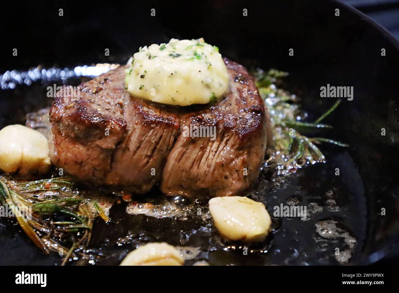 Gebratenes Filet Mignon Steak mit Kräutern in gusseiserner Pfanne Stockfoto