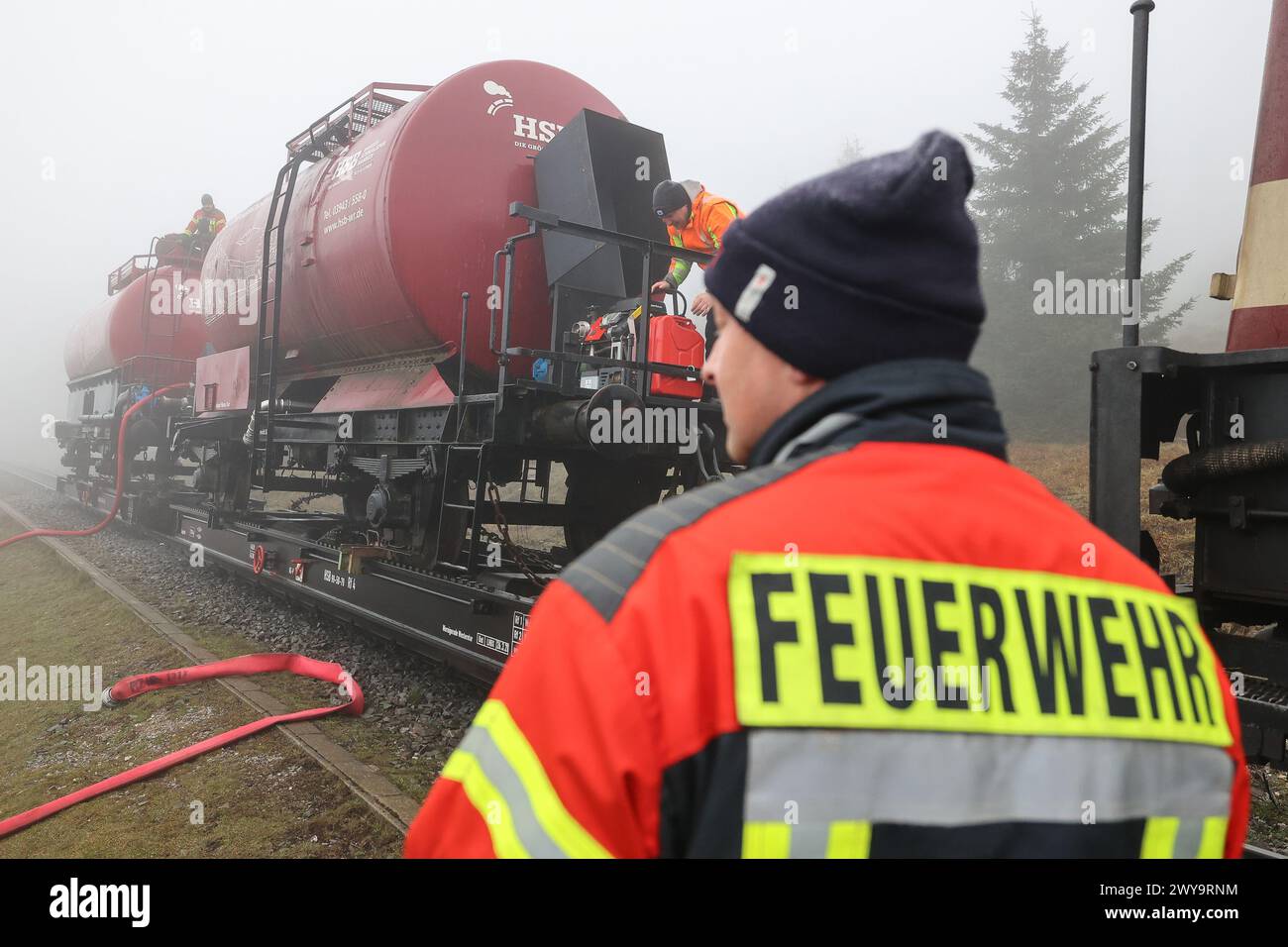 Schierke, Deutschland. April 2024. Zwei Kesselwagen der Harzer Schmalspurbahn (HSB) stehen auf dem Goethe-Aufstieg im Harz. Ein Löschwasserbehälter mit einer Kapazität von 100.000 Litern Löschwasser für den Brandschutz wird von der Feuerwehr Wernigerode in einer Höhe von 950 m gefüllt Quelle: Peter Gercke/dpa-Zentralbild/dpa/Alamy Live News Stockfoto