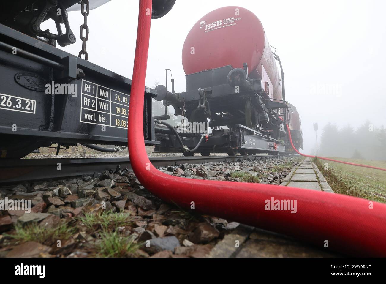 Schierke, Deutschland. April 2024. Zwei Kesselwagen der Harzer Schmalspurbahn (HSB) stehen auf dem Goethe-Aufstieg im Harz. Ein Löschwasserbehälter mit einer Kapazität von 100.000 Litern Löschwasser für den Brandschutz wird von der Feuerwehr Wernigerode in einer Höhe von 950 m gefüllt Quelle: Peter Gercke/dpa-Zentralbild/dpa/Alamy Live News Stockfoto