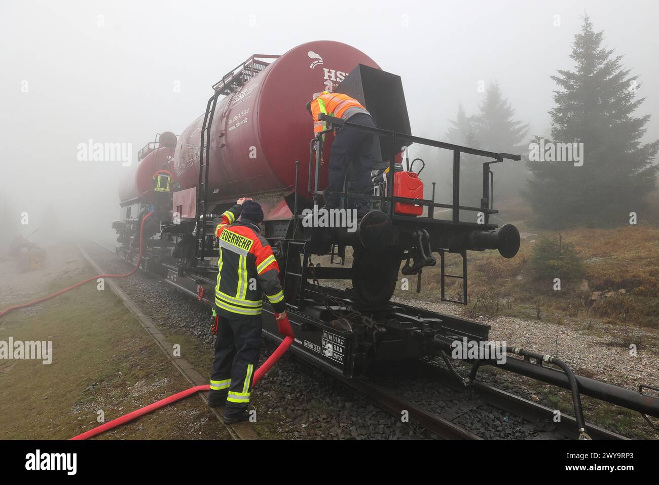 Schierke, Deutschland. April 2024. Zwei Kesselwagen der Harzer Schmalspurbahn (HSB) stehen auf dem Goethe-Aufstieg im Harz. Ein Löschwasserbehälter mit einer Kapazität von 100.000 Litern Löschwasser für den Brandschutz wird von der Feuerwehr Wernigerode in einer Höhe von 950 m gefüllt Quelle: Peter Gercke/dpa-Zentralbild/dpa/Alamy Live News Stockfoto