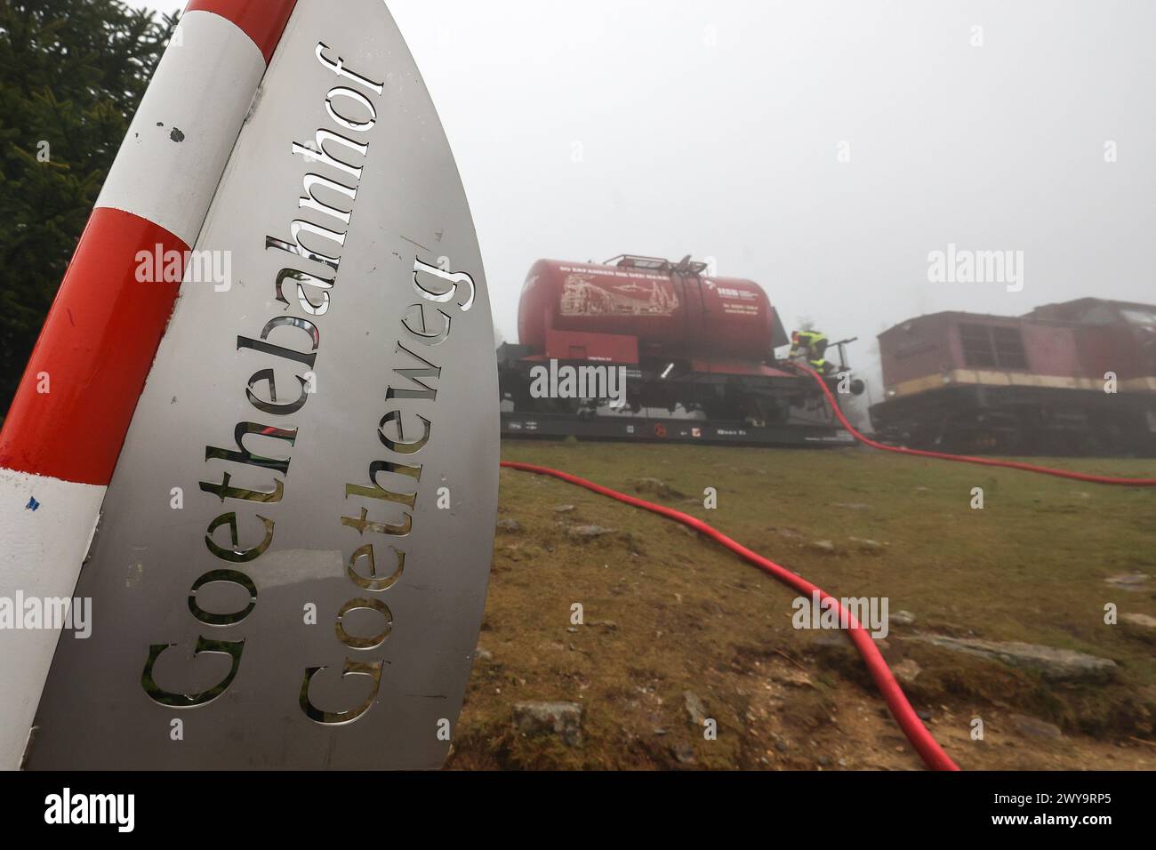 Schierke, Deutschland. April 2024. Zwei Kesselwagen der Harzer Schmalspurbahn (HSB) stehen auf dem Goethe-Aufstieg im Harz. Ein Löschwasserbehälter mit einer Kapazität von 100.000 Litern Löschwasser für den Brandschutz wird von der Feuerwehr Wernigerode in einer Höhe von 950 m gefüllt Quelle: Peter Gercke/dpa-Zentralbild/dpa/Alamy Live News Stockfoto
