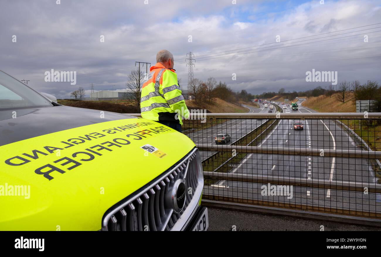 Verkehrsoffizier der Highways England beobachtet den Verkehrsfluss von einer Brücke über die A1M, England. Stockfoto