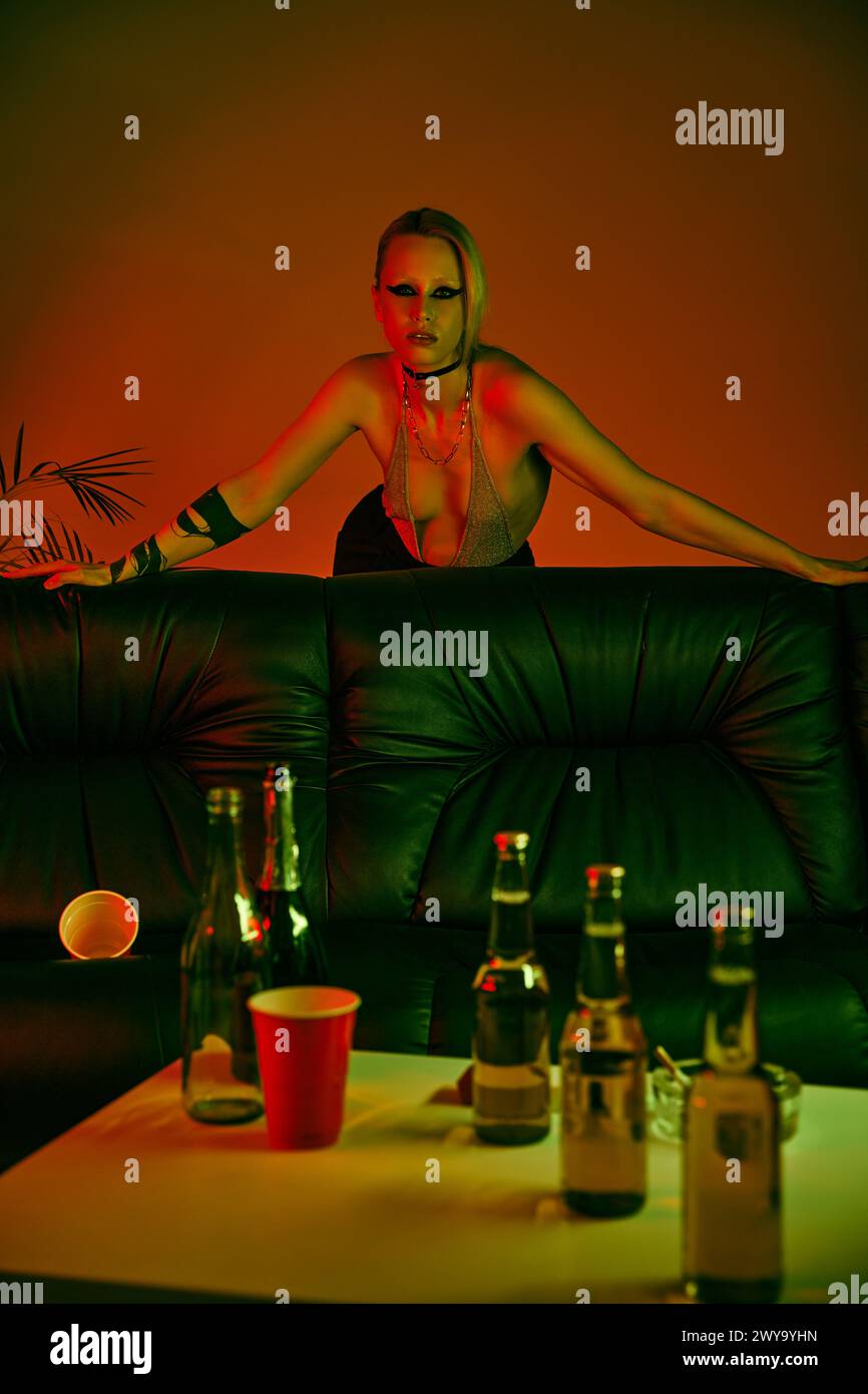 Frau saß auf der Couch neben verschiedenen Flaschen Stockfoto