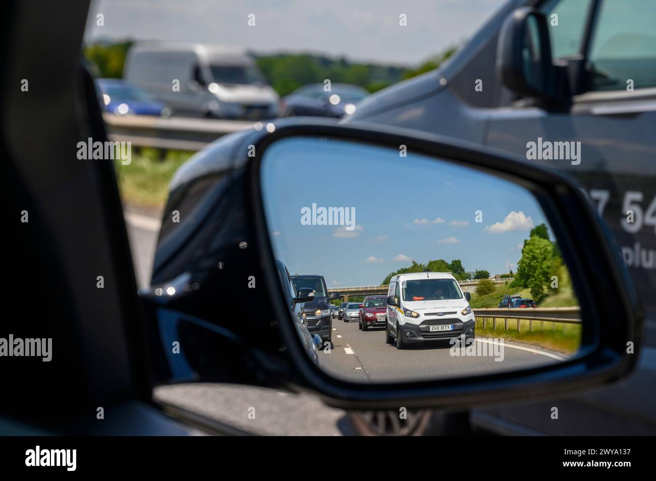 Die Warteschlange des Verkehrs wurde im Außenspiegel eines Autos auf der Autobahn M62 in England gesehen. Stockfoto