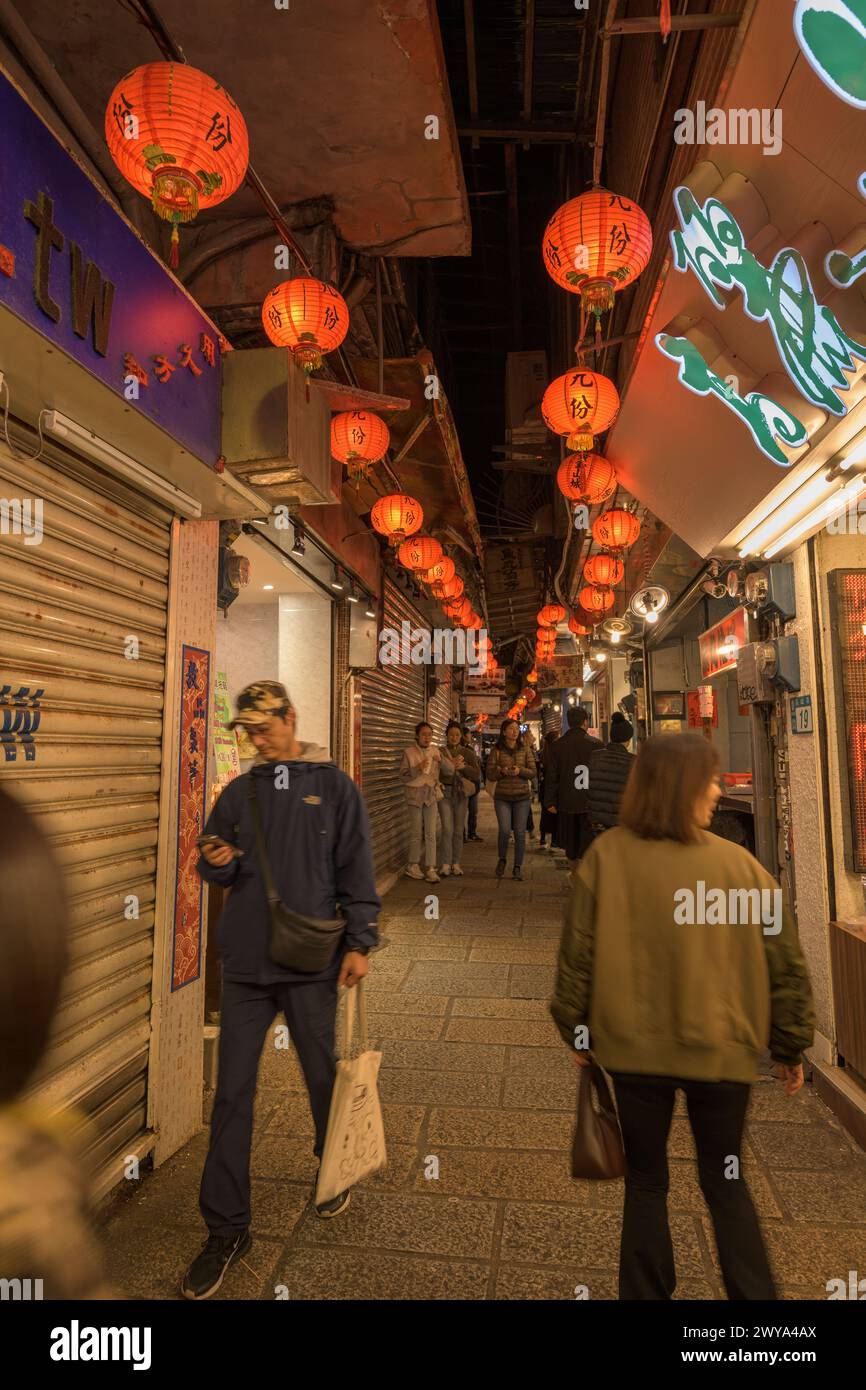 Ein überfüllter Nachtmarkt in Jiufen, beleuchtet von roten Laternen mit Geschäften und Menschen Stockfoto