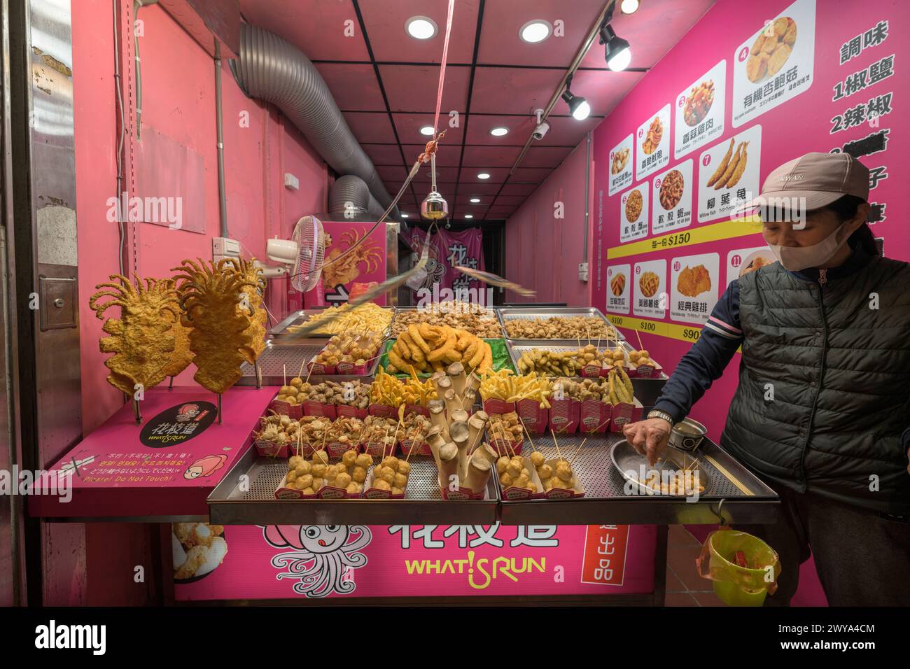 Ein Imbissstand in den Straßen von Jiufen, voller köstlicher frittierter Köstlichkeiten und einer sichtbaren Speisekarte Stockfoto
