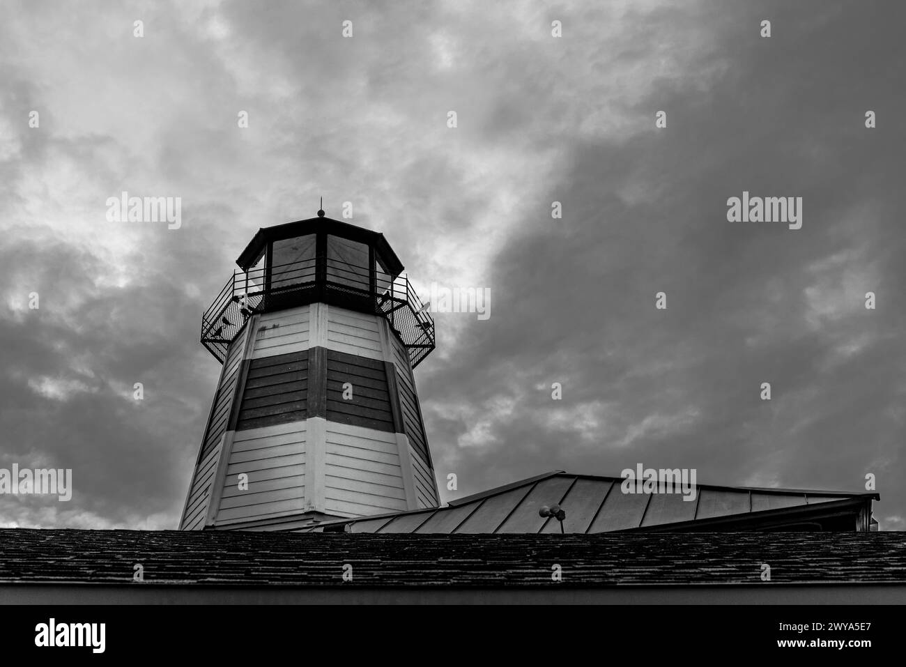 Eine monochrome Aufnahme eines hohen Leuchtturms unter einem bedeckten Himmel. Stockfoto