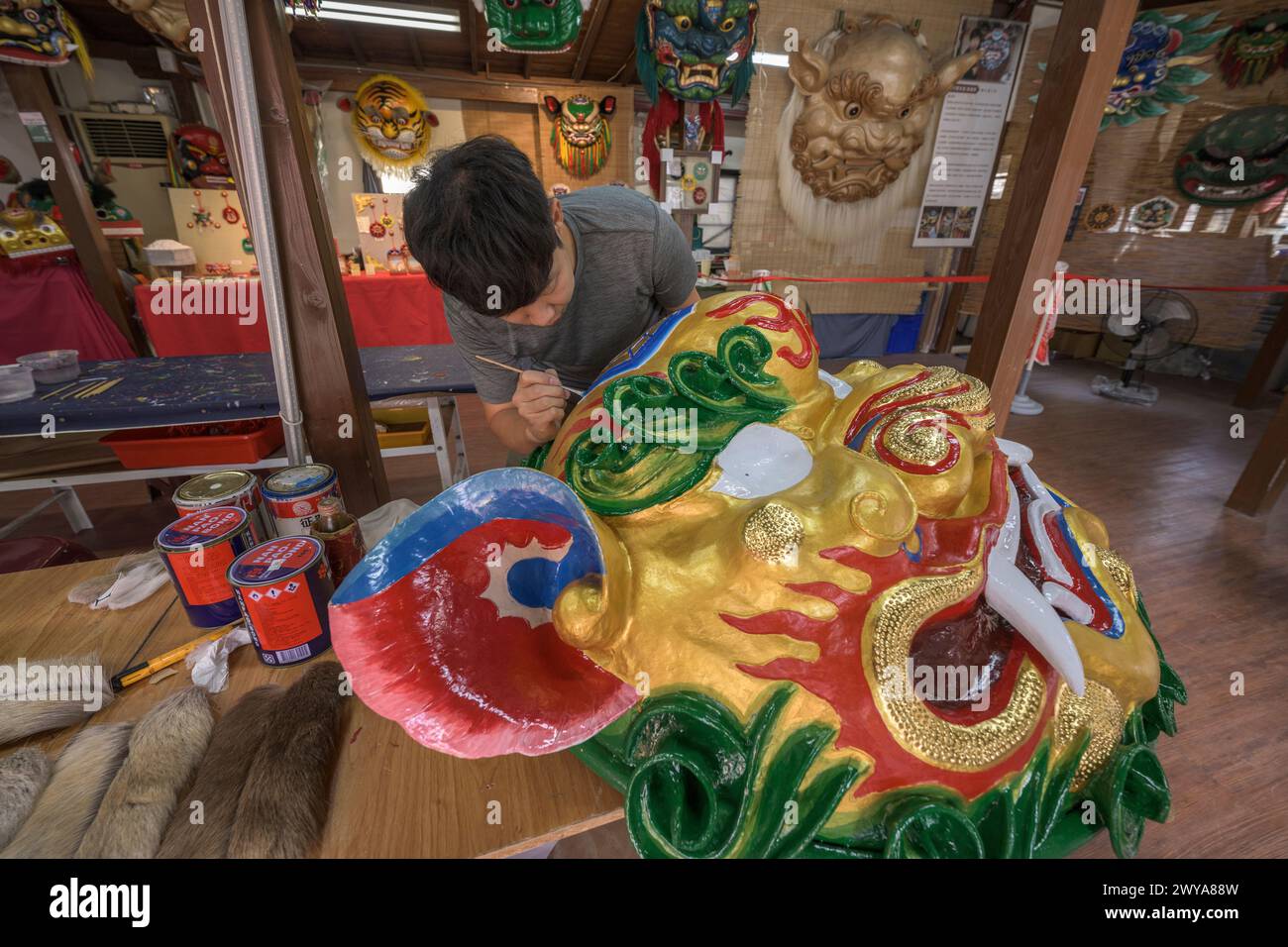 Nahaufnahme eines handwerklichen Gemäldes aufwendige Entwürfe auf einer brillanten goldenen Drachenskulptur Stockfoto