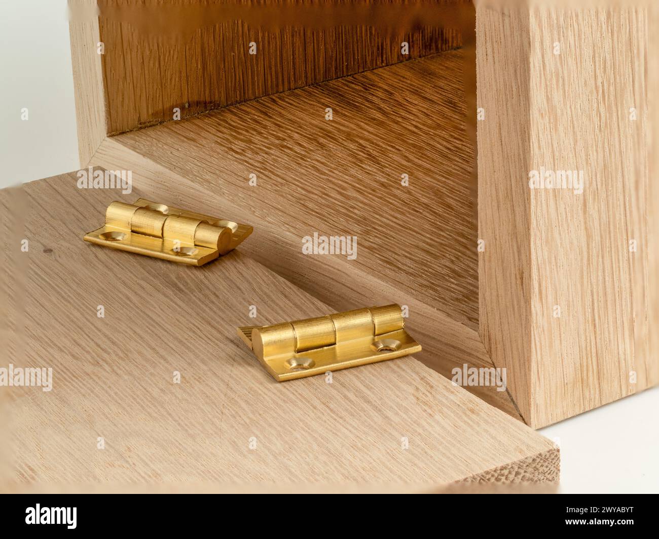 Zwei kleine gezogene Stoßscharniere aus Messing, die an einer Schmuckschatulle befestigt werden können Stockfoto