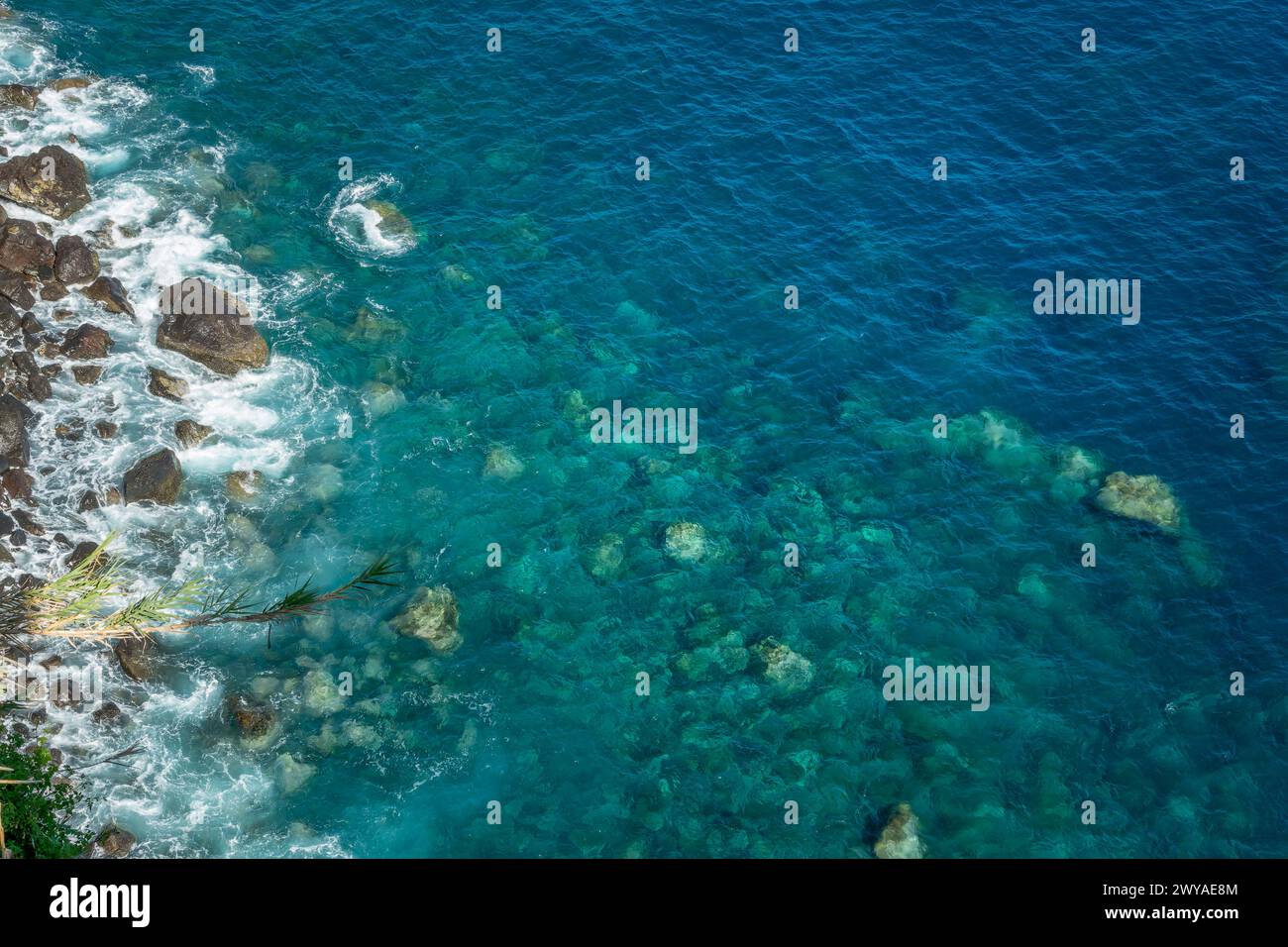 Blick auf die Felsen und das blaue, unberührte Meer mit klarem, transparentem Wasser. Ozeanhintergrund mit Kopierbereich Stockfoto