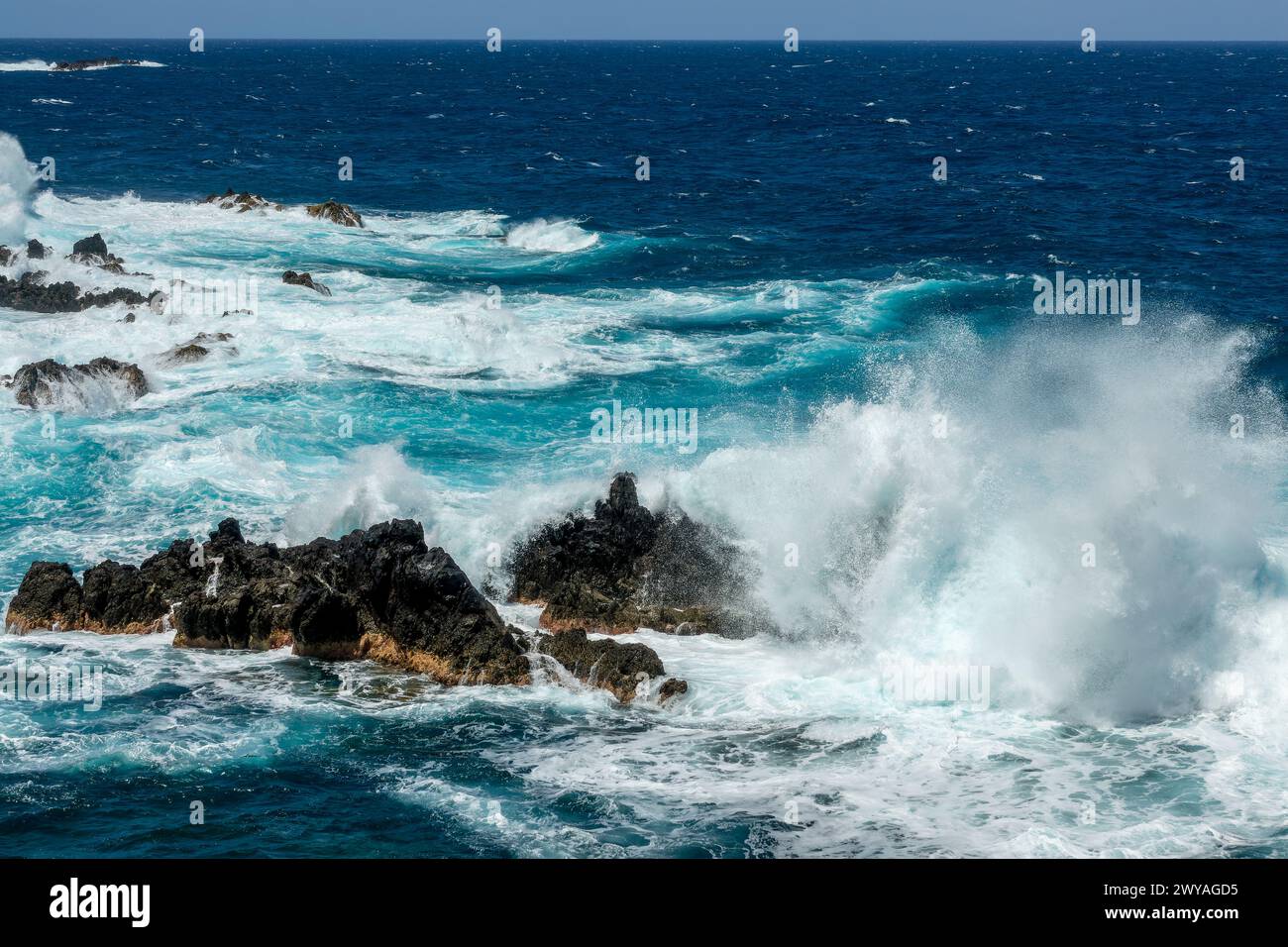 Lavasteine und Wellen in Porto Moniz, an der Küste der Insel Madeira, Portugal Stockfoto