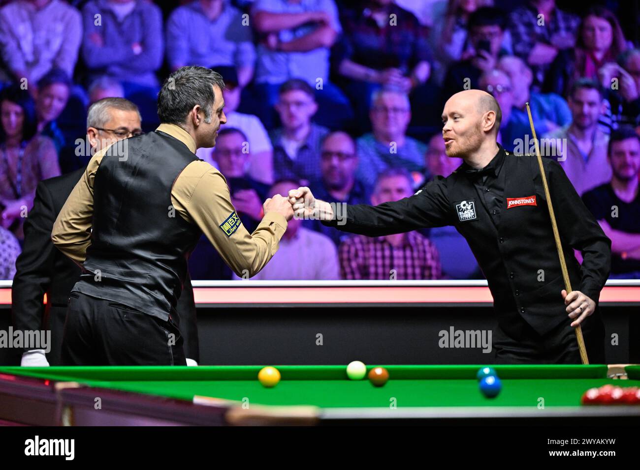 Die beiden Spieler Ronnie O'Sullivan (links) und Gary Wilson (rechts) stoßen vor dem Spiel bei den Johnstone’s Paint Tour Championships in Manchester Central, Manchester, Großbritannien, 5. April 2024 (Foto: Cody Froggatt/News Images) Stockfoto