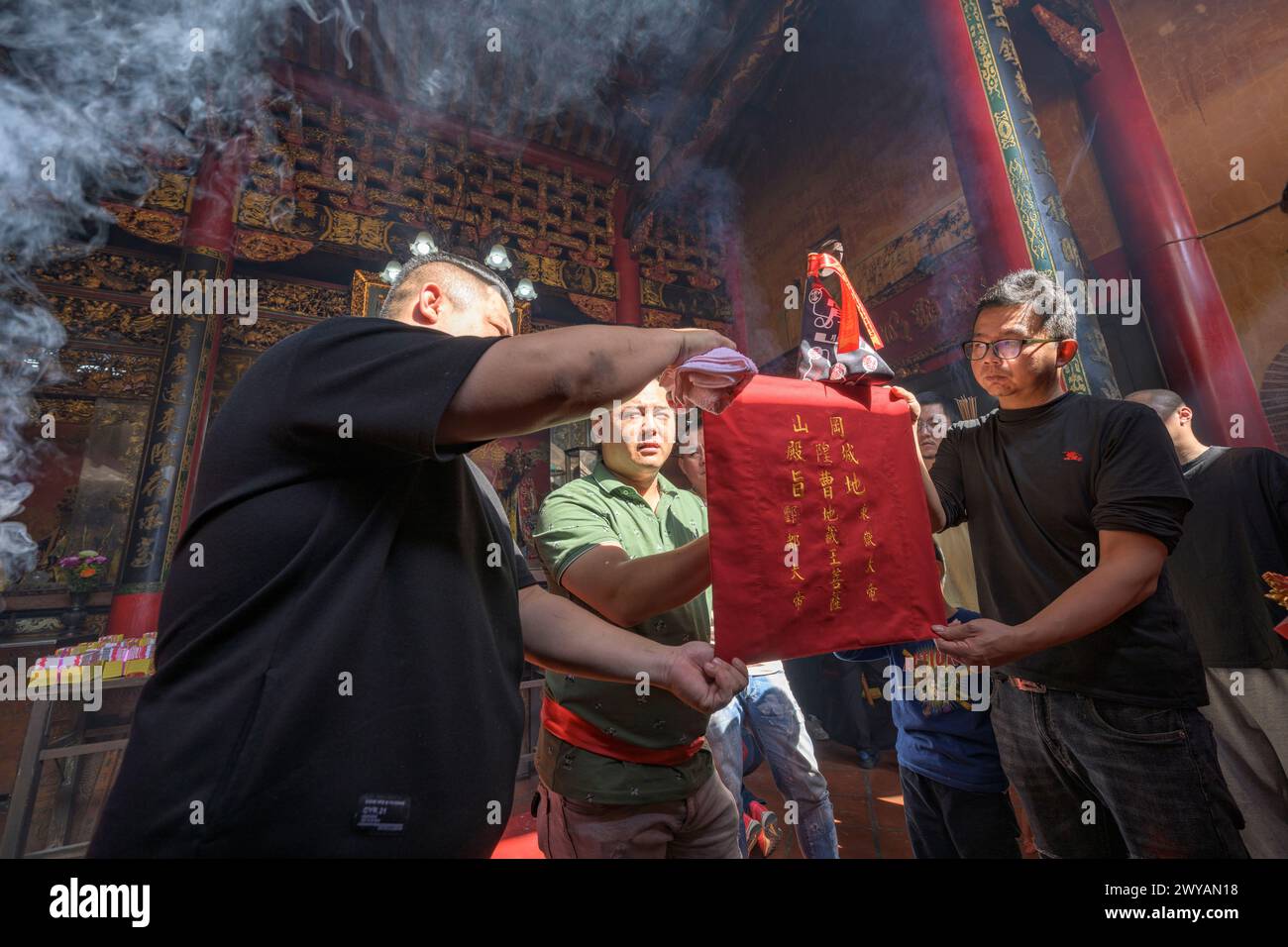 Tempelritual mit Einzelpersonen, die ein rotes Ritual-Banner halten Stockfoto