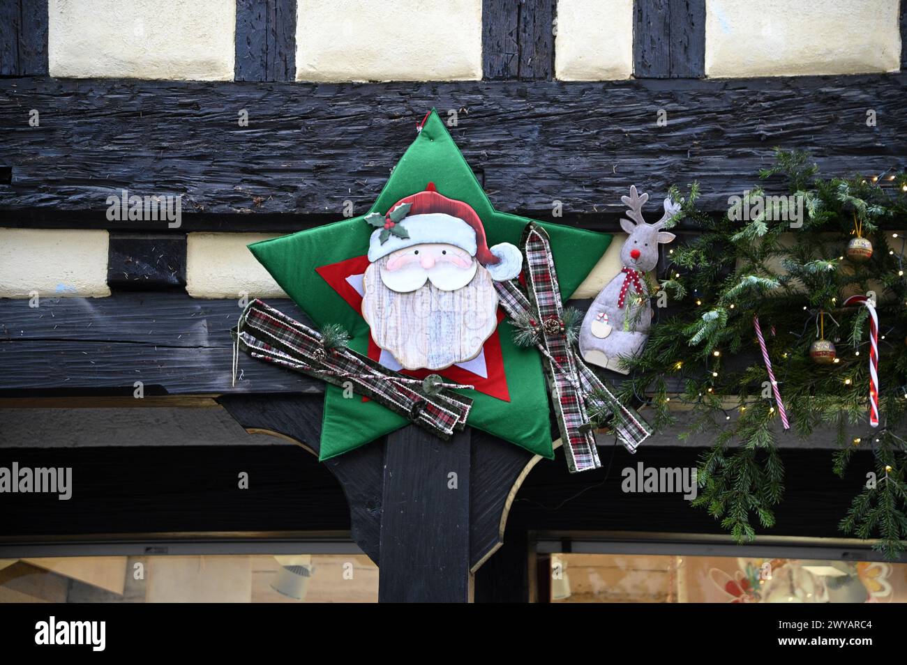Festliche Weihnachtsdekoration am antiken Fenster eines Fachwerkhauses im Elsass Frankreich. Stockfoto