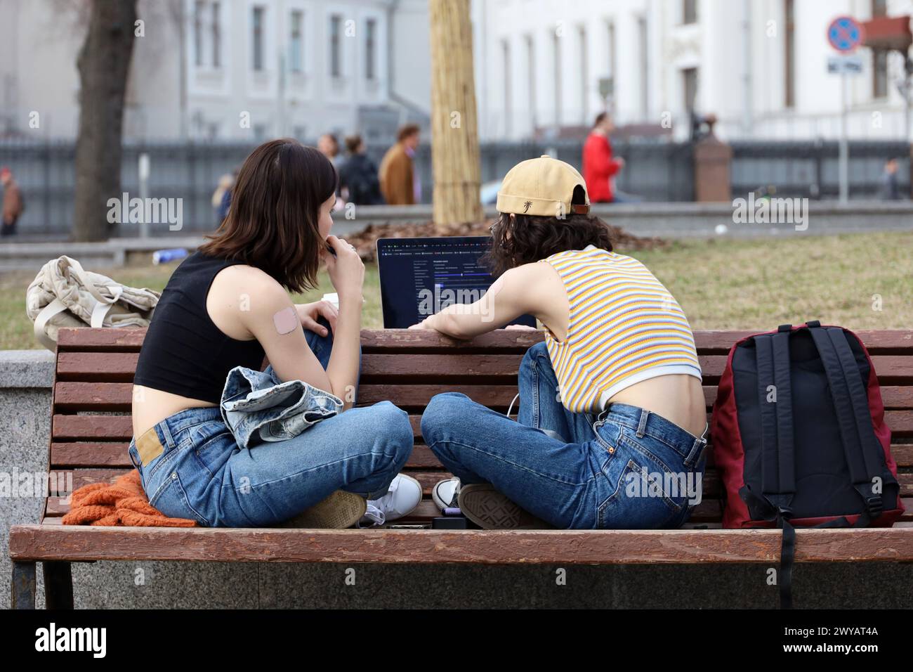 Zwei Mädchen, die im Frühling auf der Straße sitzen Stockfoto
