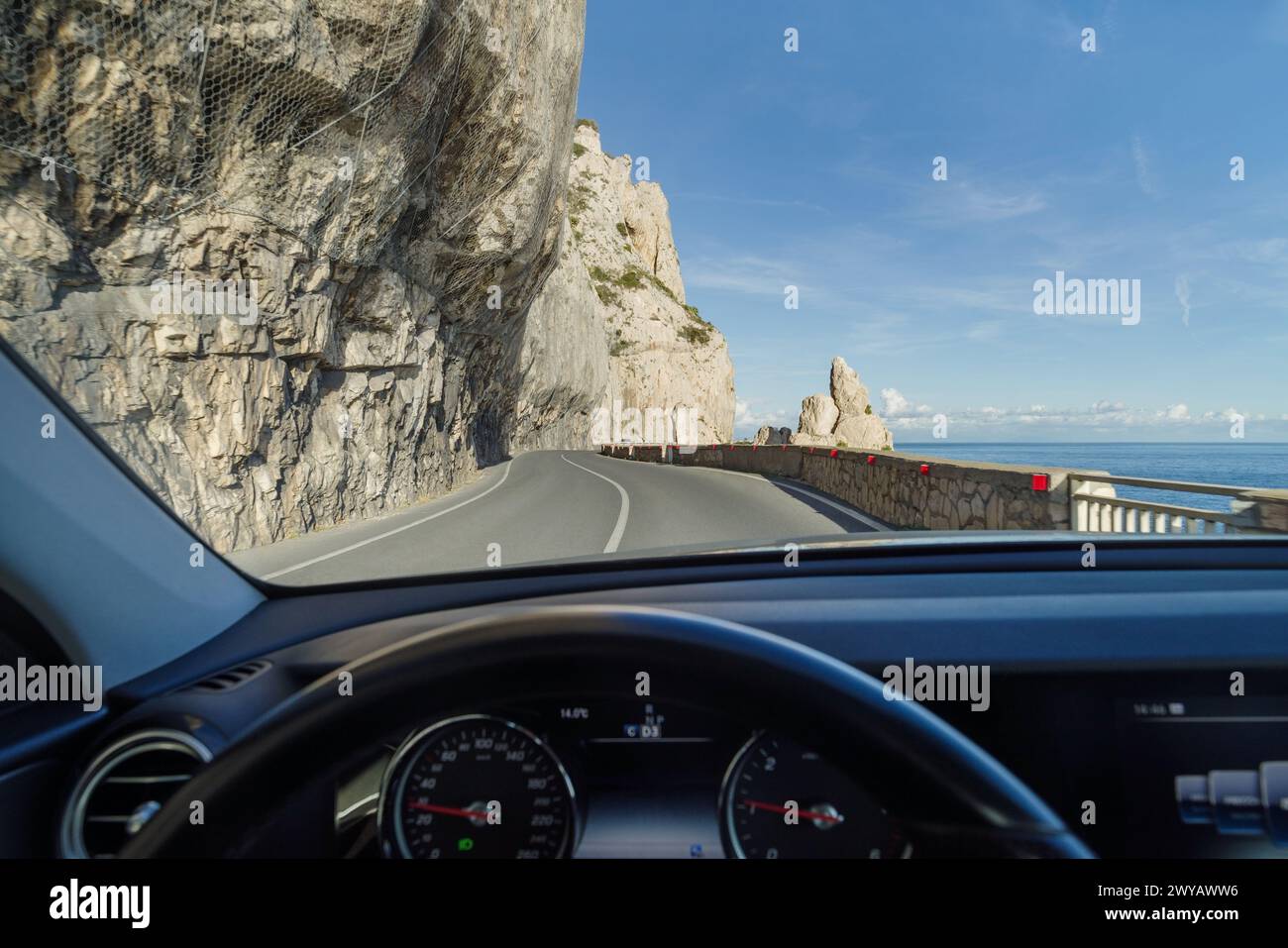 Aus dem Inneren des Autos die atemberaubende, hochgelegene Straße an den Klippen entlang der Küste von Ligurien, Italien Stockfoto