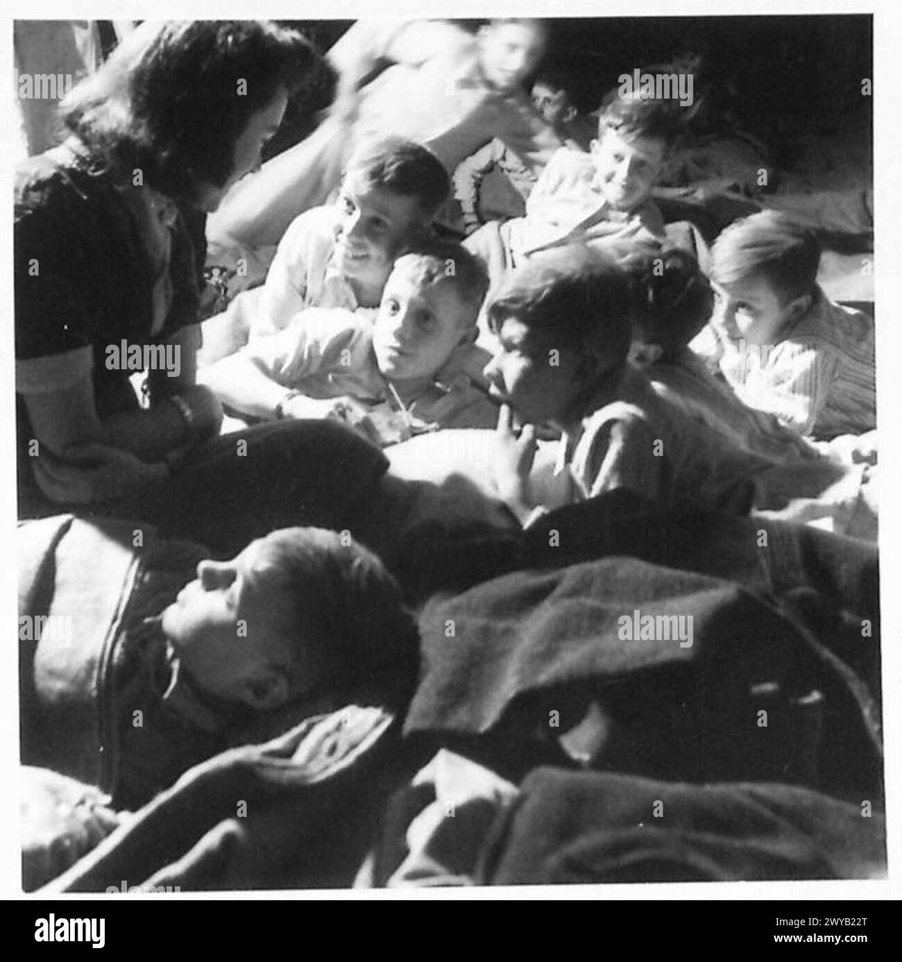 Niederländische Kinder im Evakuierungszentrum Tilburg werden von ihrem Gruppenleiter über England informiert. Stockfoto