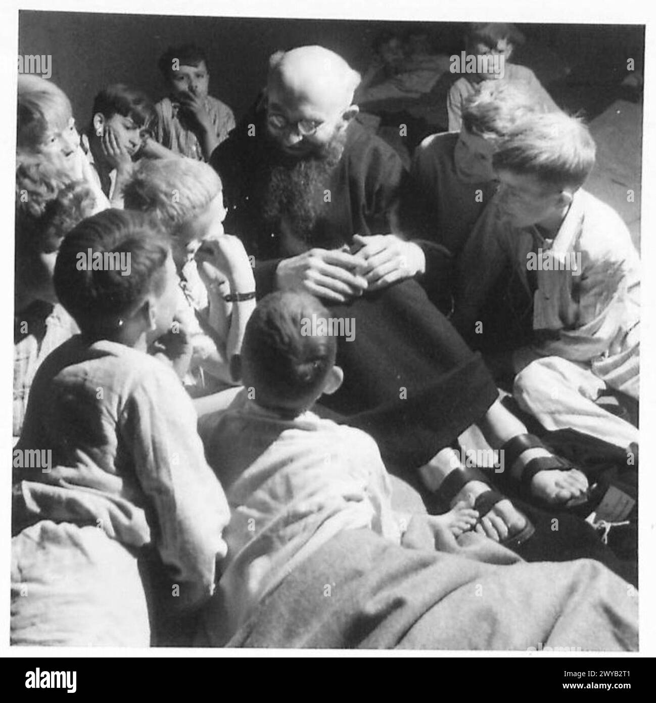 Niederländische Kinder im Evakuierungszentrum Tilburg hören Geschichten von einem römisch-katholischen Priester vor dem Schlafengehen während ihrer Evakuierung nach England. Stockfoto