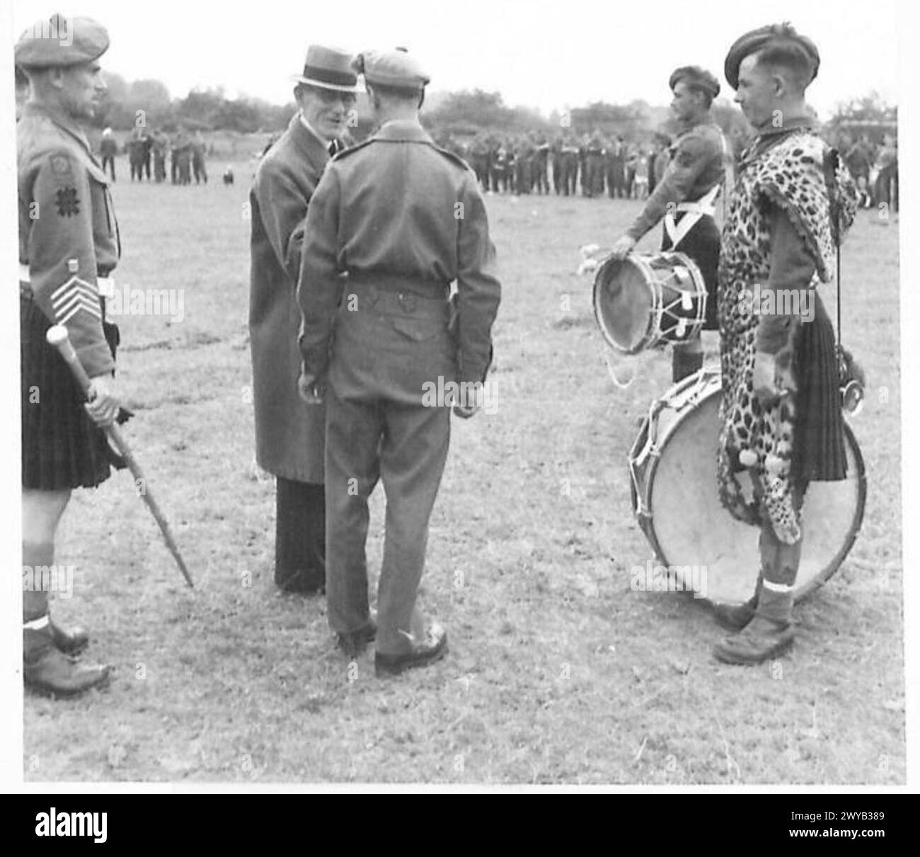 SCHOTTISCHE PFEIFENBAND UNTERHÄLT BEIM FUSSBALLSPIEL - Originaltitel aus der Kriegszeit: Der Bürgermeister von La Delivrande, Jean-Merie Saliou, der die Pipe Band eines schottischen Regiments bei einem Fußballspiel in der Stadt inspiziert. Fotografisches negativ, britische Armee, 21. Armeegruppe Stockfoto