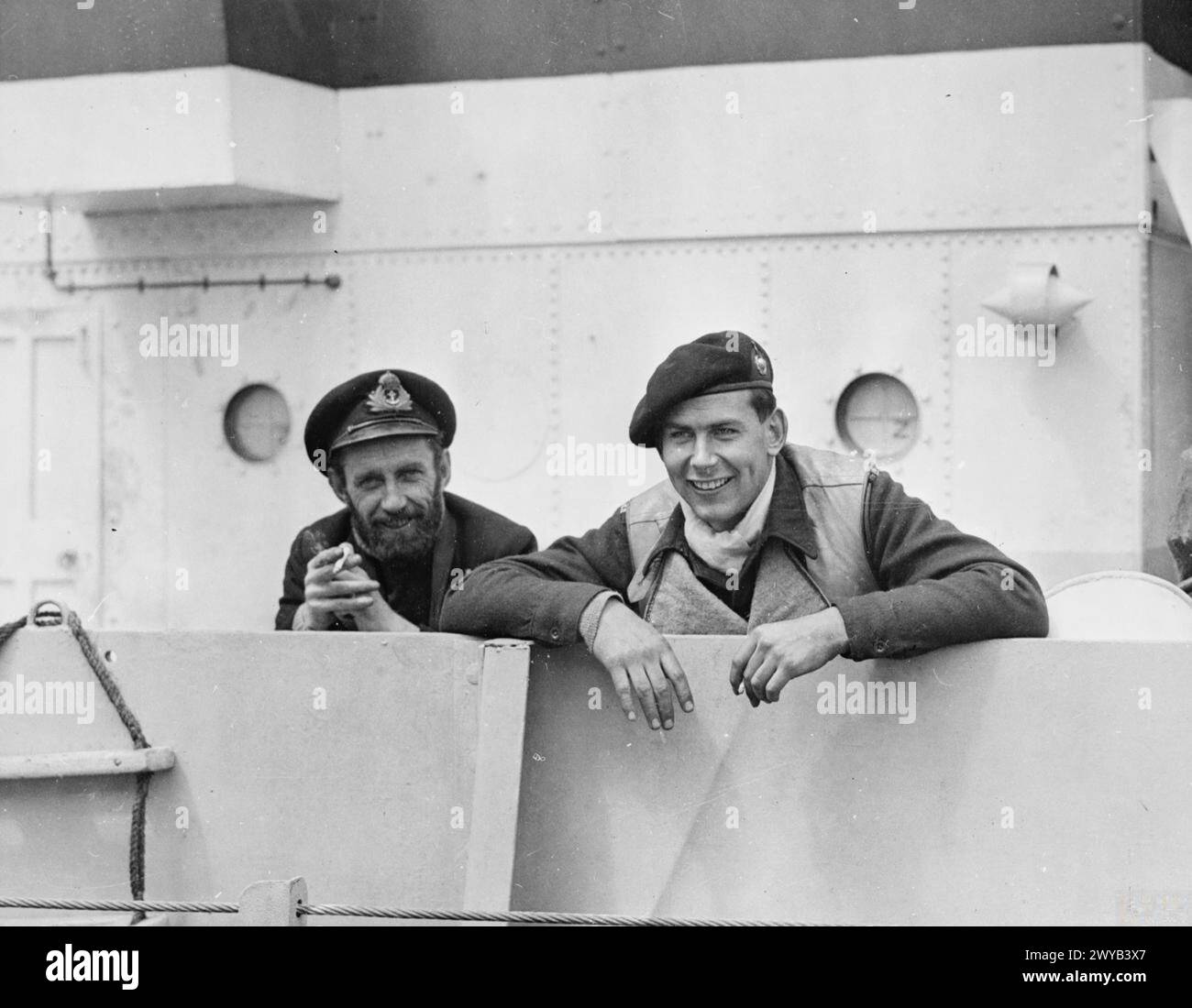 BEFREIUNG EUROPAS: EIN LANDUNGSBOOT (GUN) UNTERSTÜTZT DIE LANDUNGEN DER ALLIIERTEN IN DER NORMANDIE. 5. BIS 8. JUNI 1944, VOR DER INVASIONSKÜSTE. SERIE, DIE DAS LEBEN AN BORD VOR, WÄHREND UND NACH DEM D-DAY ZEIGT. - Lieut H P O'DEA, RNR, aus Shirley, Southampton, Commanding Officer des Landungsfahrzeugs und Lieut Ian Birdseye, RM, aus South Croydon an Deck nach Beschuss der deutschen Strandverteidigung (6. Juni). , Stockfoto