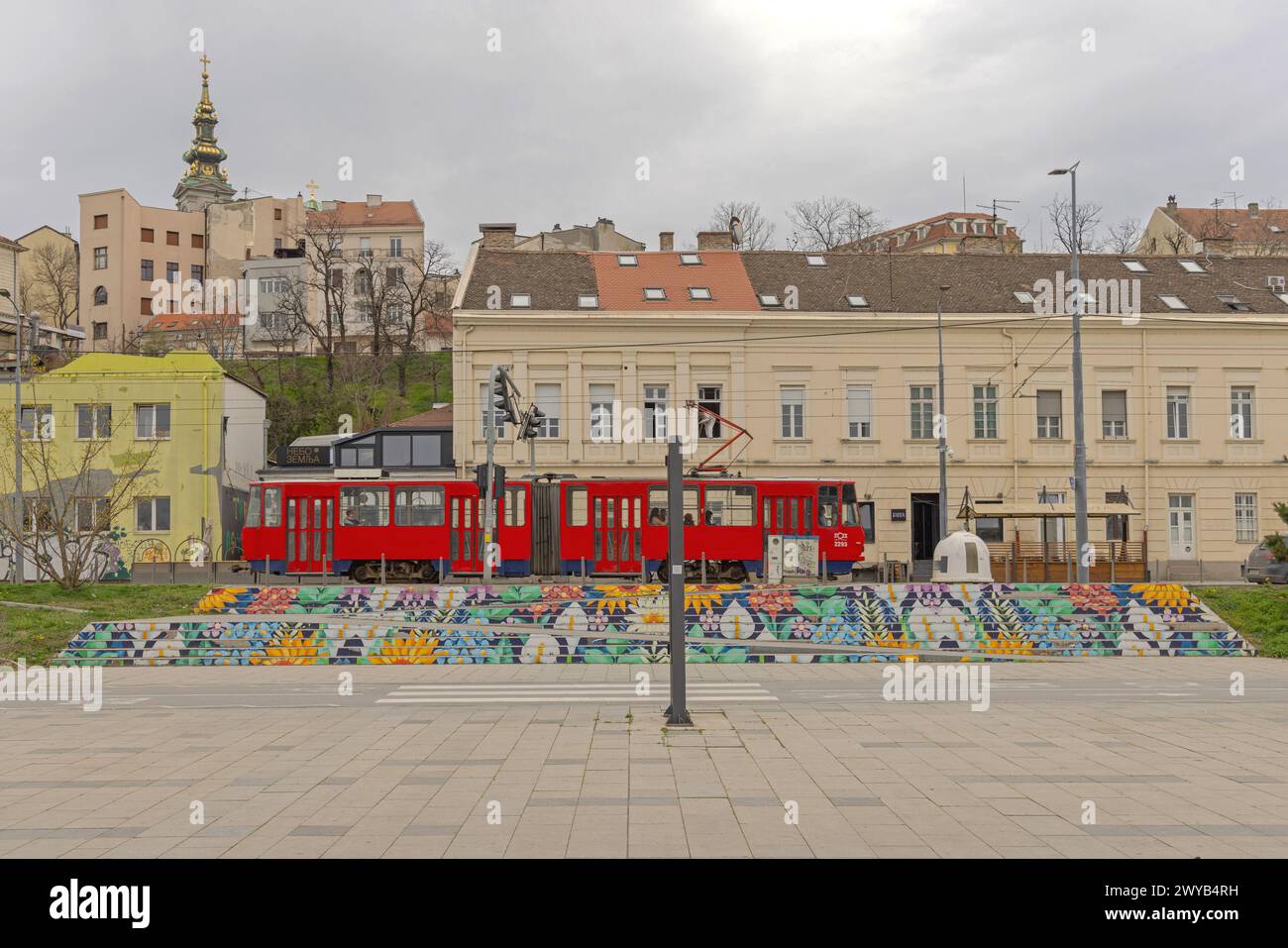 Belgrad, Serbien - 11. März 2024: Farbenfrohe Treppen und rote Straßenbahn vor den Altstadthäusern bei Winterblick vom Fluss. Stockfoto