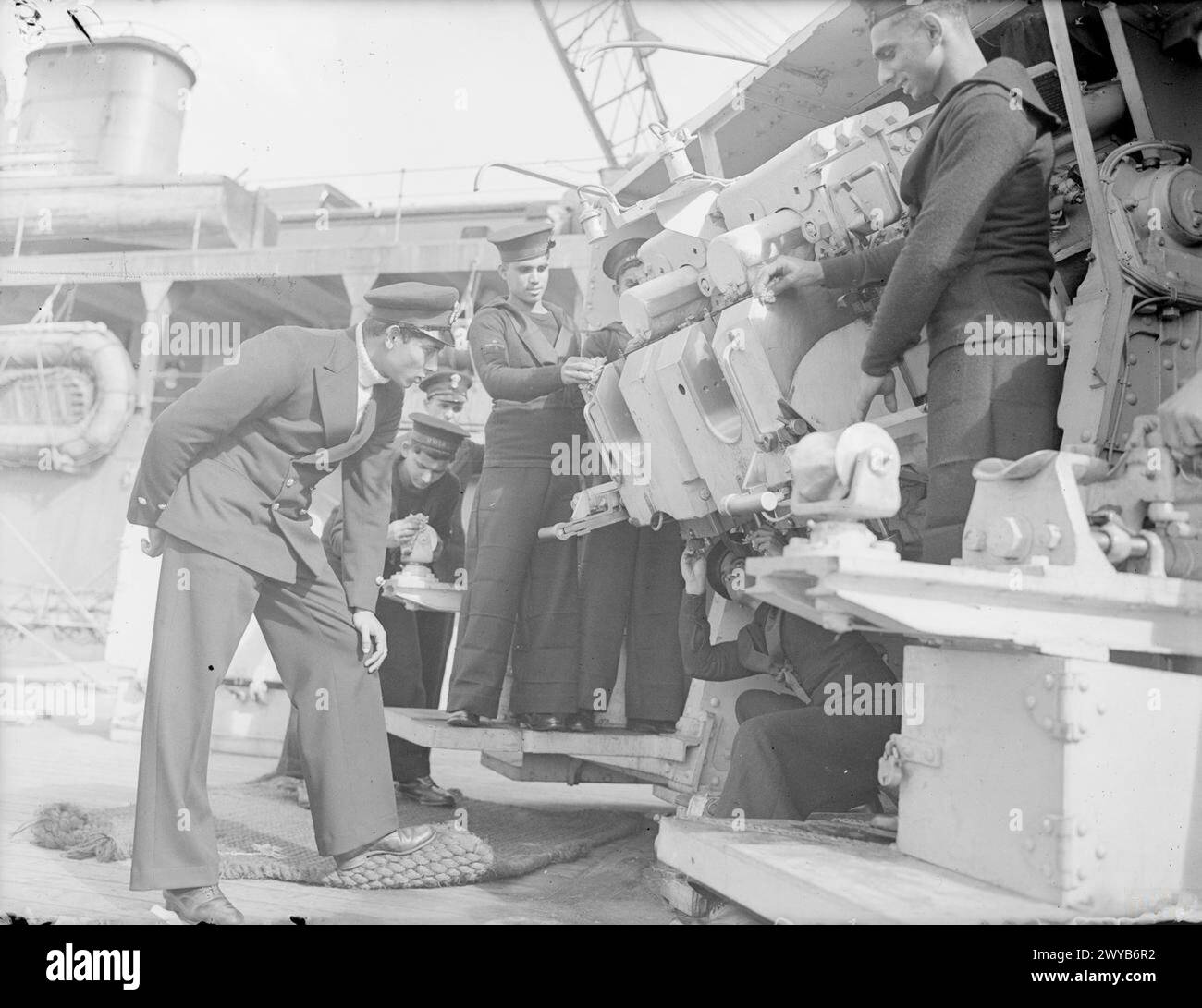 Petty Officer, der im August 1943 bei Scapa Flow die Verstopfung einer Pistole inspiziert, die von der indischen Crew an Bord von HMIS Godavari gereinigt wurde. Stockfoto Petty Officer, der im August 1943 bei Scapa Flow die Verstopfung einer Pistole inspiziert, die von der indischen Crew an Bord von HMIS Godavari gereinigt wurde. Stockfoto