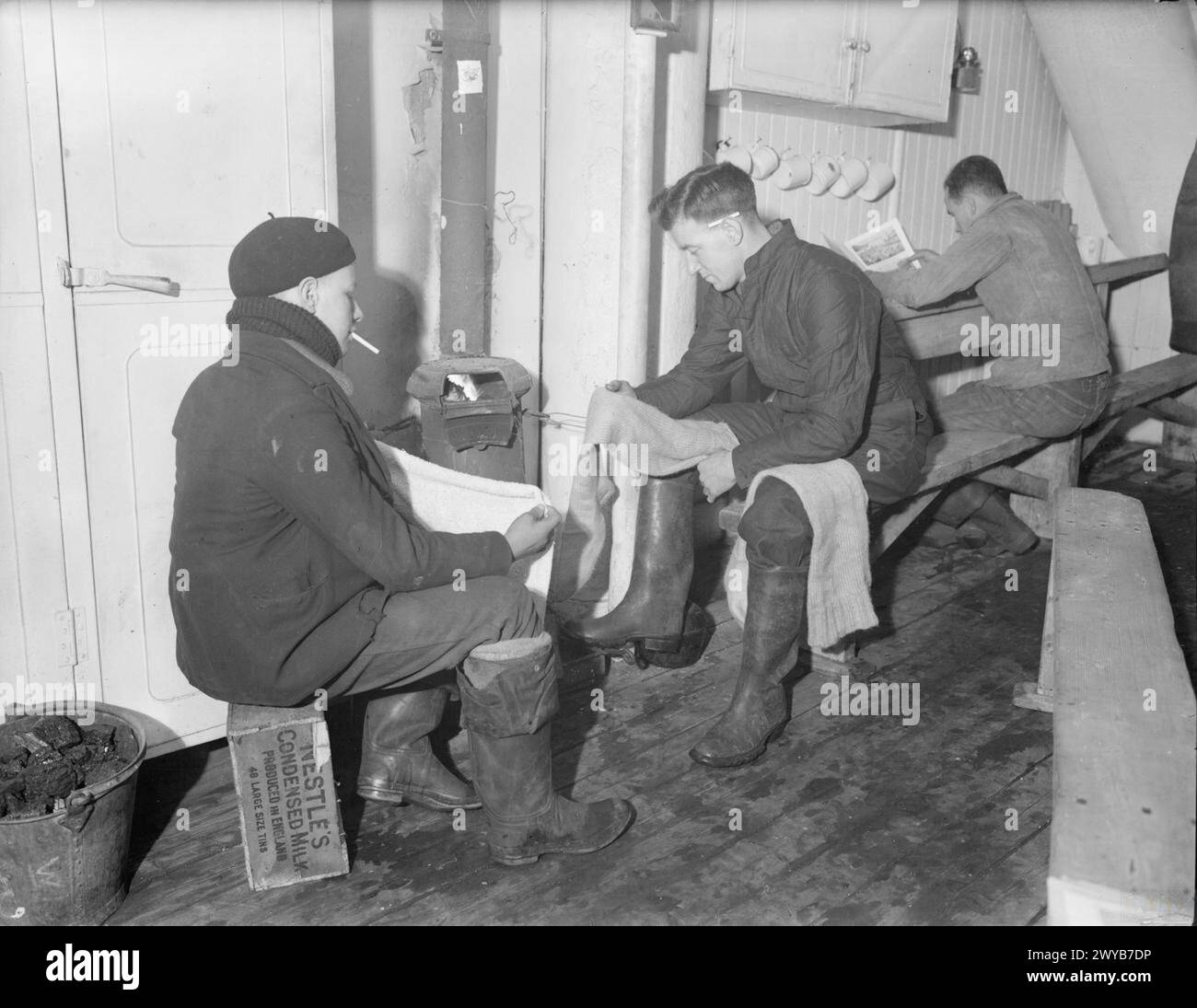Am 24. Januar 1942 schloss sich ein Frachtschiff einem eskortierten Konvoi bei Methil Anchorage an, wobei die Besatzung während der Fahrt Kleidung und Seeschuhe pflegte. Stockfoto