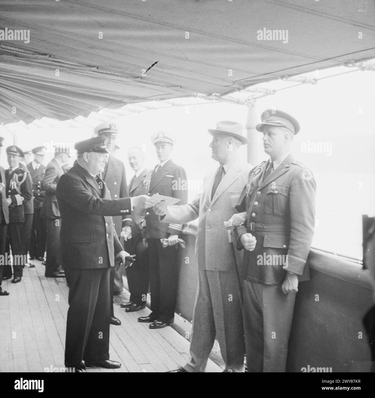 Präsident Franklin D. Roosevelt erhält einen persönlichen Brief von König George VI., der von Premierminister Winston Churchill an Bord der USS Augusta während der Atlantikkonferenz im August 1941 überreicht wurde. Stockfoto