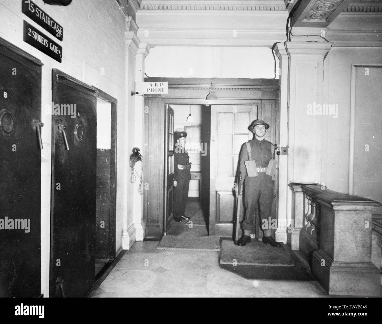 CABINET WAR ROOMS, WHITEHALL, LONDON - dieses Foto zeigt den Eingang zur Wohnung Nr. 10 Annexe, in der Churchill und seine Familie lebten, direkt über den Cabinet war Rooms und wird von zwei Royal Marines bewacht. Die offene Tür an der Seite des Fotos führt hinunter zu den Kabinettsräumen, die offene Tür an der Rückseite des Annexes. , Stockfoto