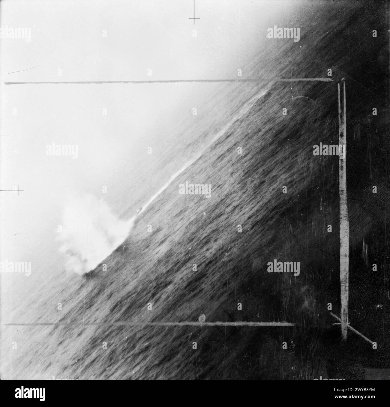 Flieger in einem Liberator-Flugzeug, die Tiefenangriffe auf ein U-Boot, das einen Konvoi angreift, zeigen Explosionen in der Nähe des Bugs, während das Heck des U-Bootes während des Zweiten Weltkriegs über Wasser bleibt Stockfoto