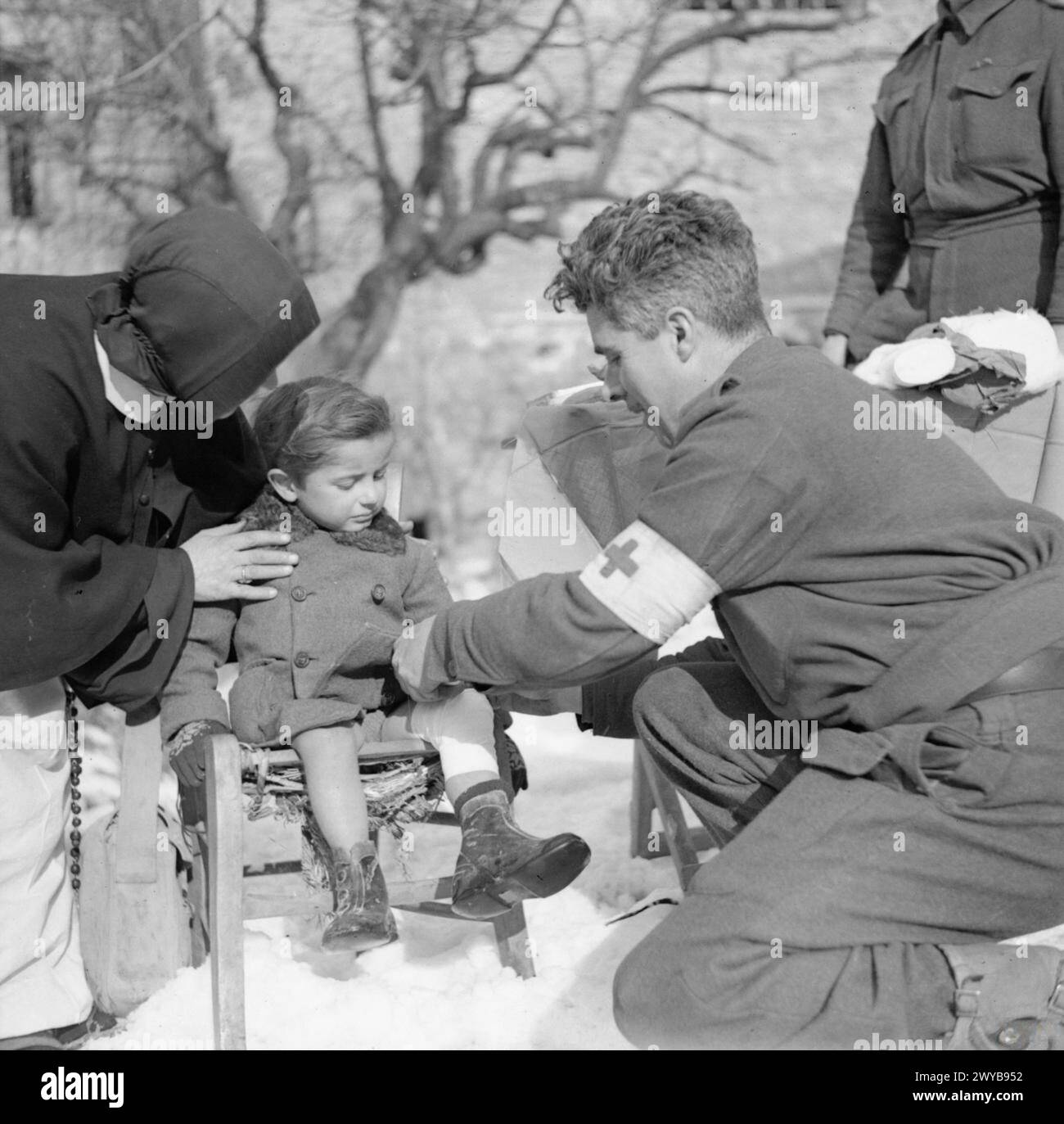 DIE BRITISCHE ARMEE IN ITALIEN 1944 - Ein Sanitäter verband das Bein eines kleinen Kindes in Casola Valsenio, 30. Januar 1945. , Stockfoto