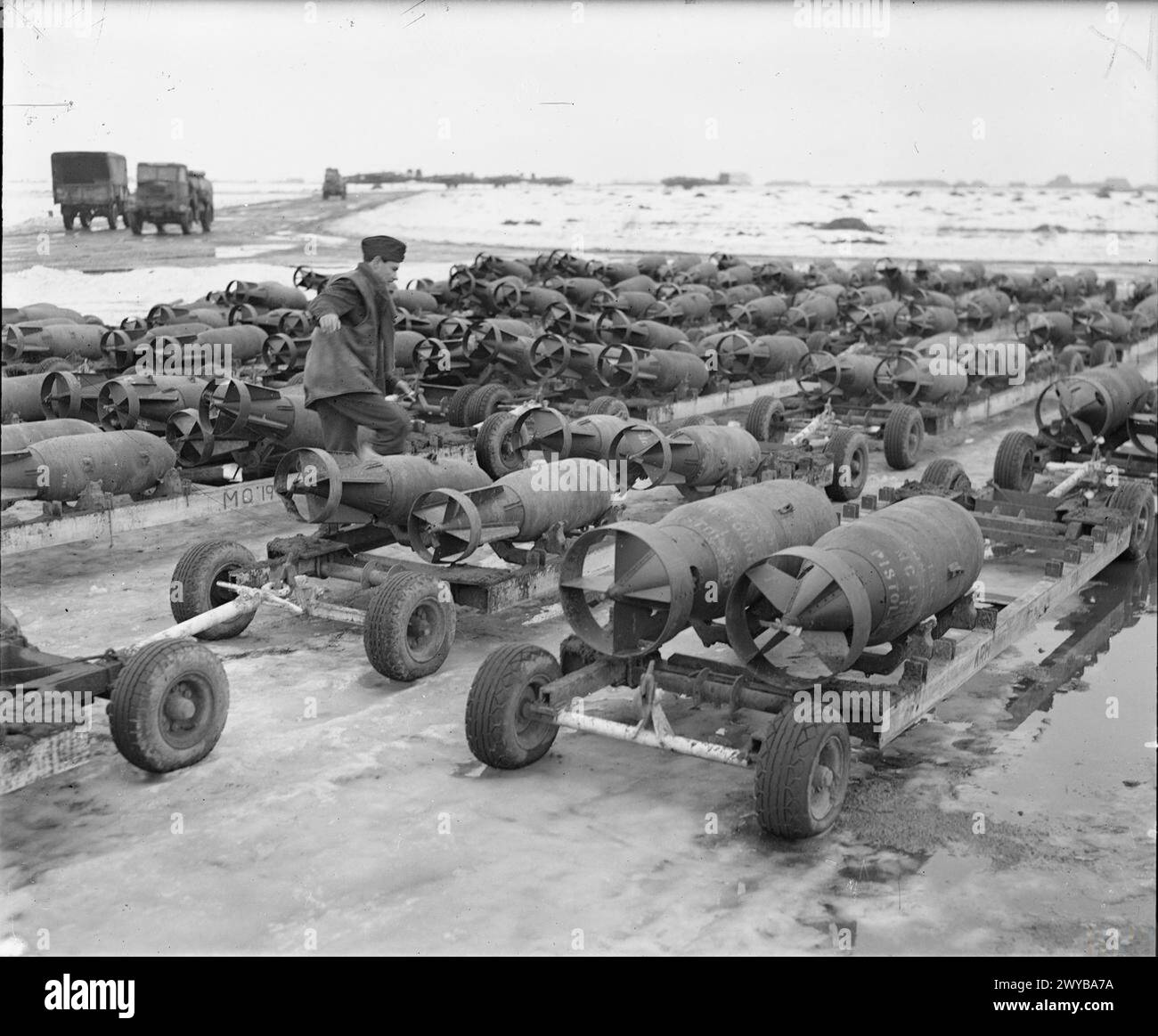 ROYAL AIR FORCE: 2. TAKTISCHE LUFTWAFFE, 1943-1945. - Linien von Bombenwagen, beladen mit 500-lb- und 1.000-lb-MC-Bomben, begleitet von einem RAF-Rüstzeug, warten im Schnee bei B50/Vitry-en-Artois, Frankreich, um zu den zurückkehrenden nordamerikanischen Mitchells von No. 137 Wing, No. 2, befördert zu werden. , Royal Air Force, Gruppe 2, Royal Air Force, Wartungseinheit, 201 Stockfoto