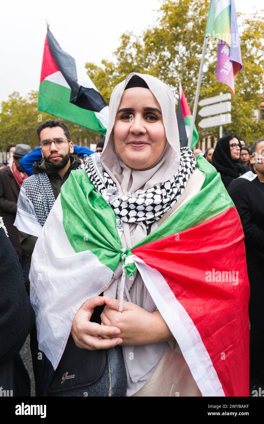 Eine Dame, palästinensische Flagge in cape und Keffieh Schal um ihren Hals. Demonstration für den Frieden in Gaza, gegen die Massaker und die Berufung. Stockfoto
