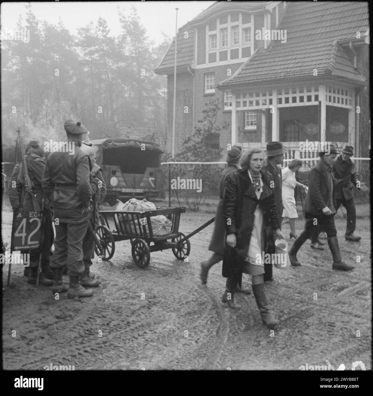 Schottische Truppen der britischen Armee beobachten deutsche Flüchtlinge, die am 19. Februar 1945 durch Bedburg bei Kleve in Nordwesteuropa zurückkehren. Stockfoto