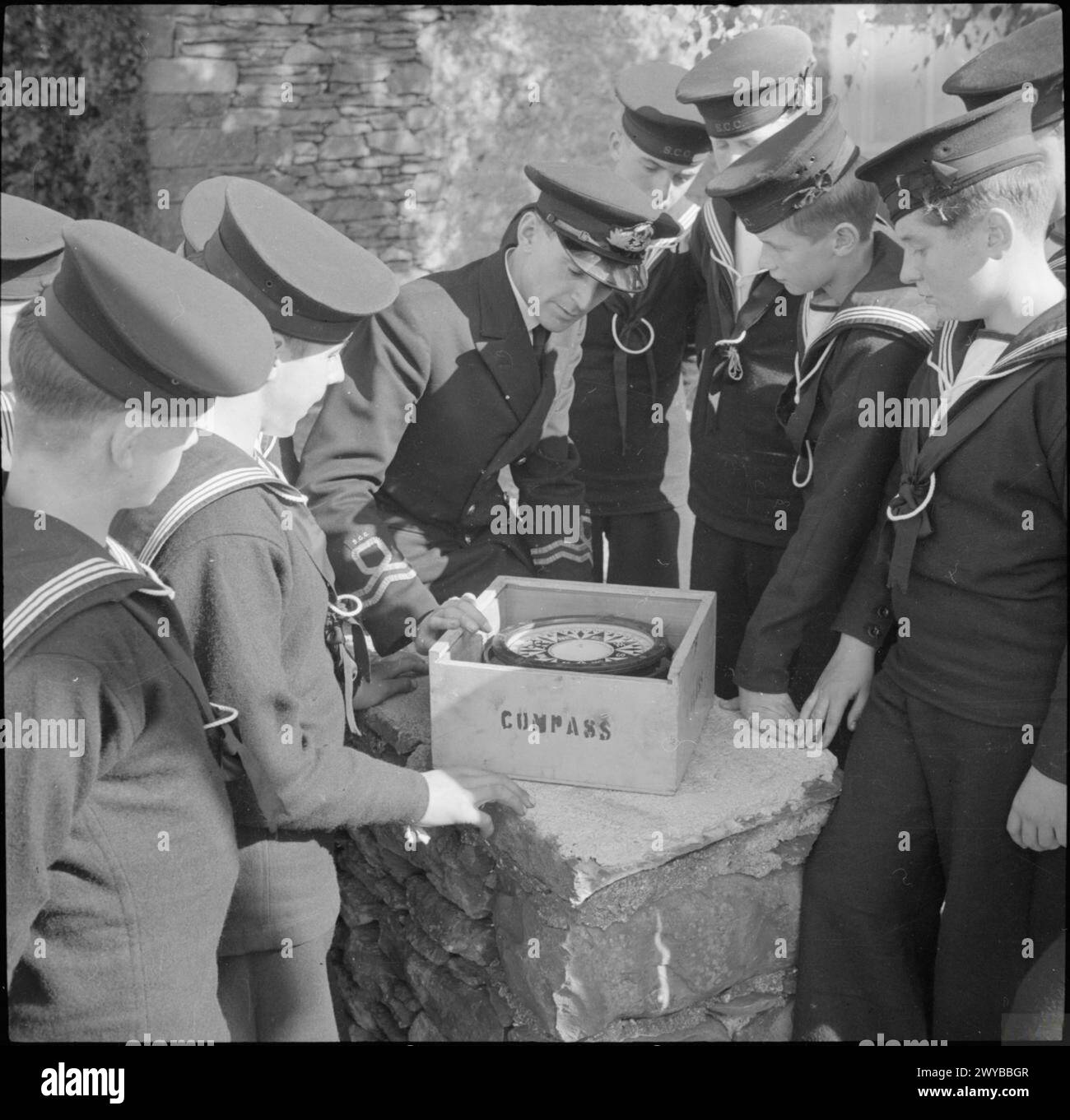 Die Seekadetten an Bord der HMS Undine in Bowness-on-Windermere, England, 1943, werden von einem Offizier der Royal Naval Volunteer Reserve im Kompass ausgebildet. Stockfoto