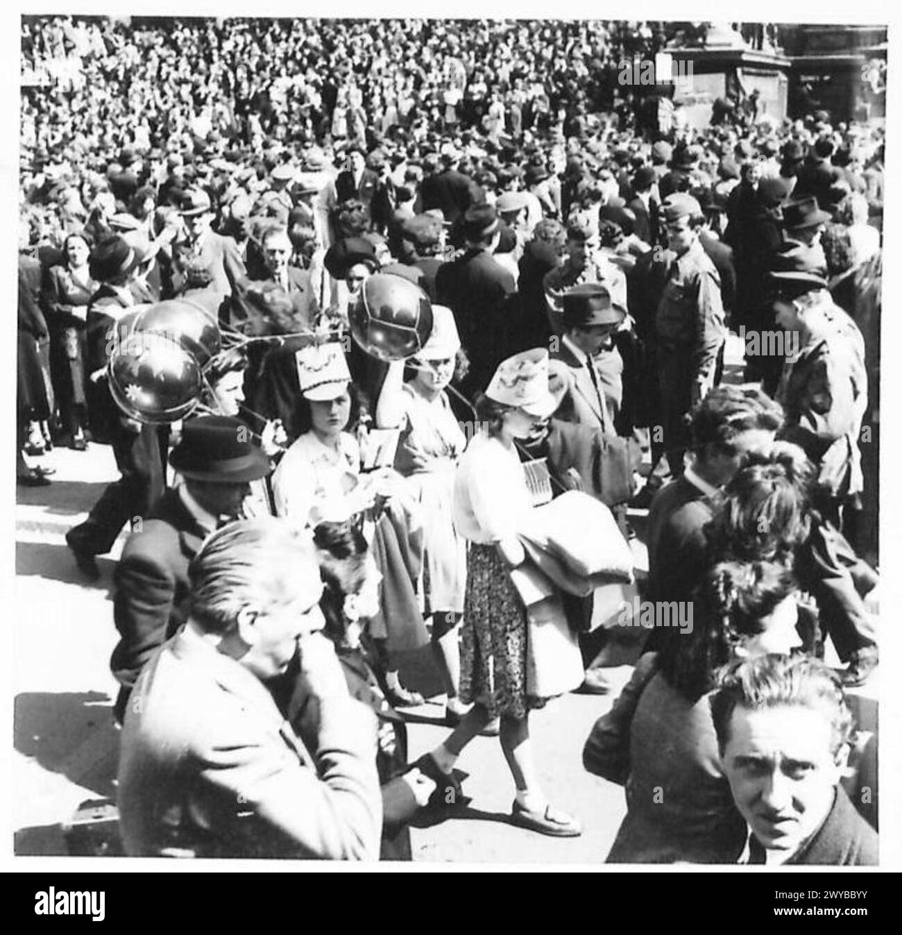 Friedensfeiern in Brüssel, bei denen Mädchen Ballons halten und Papierhüte tragen, vor der Bourse, die von der britischen Armee, 21. Armeegruppe, gefangen genommen wurde. Stockfoto