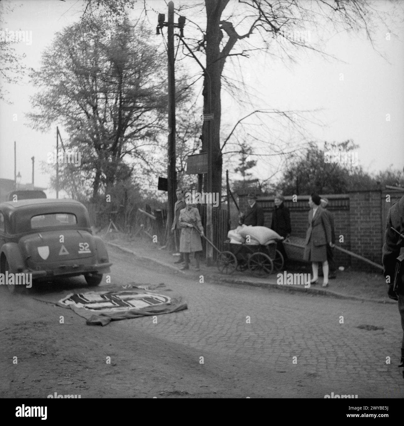 Schottische Truppen nahmen Celle ein. Ein britisches Transportfahrzeug fährt über eine deutsche Flagge, die auf der Straße liegt. Stockfoto