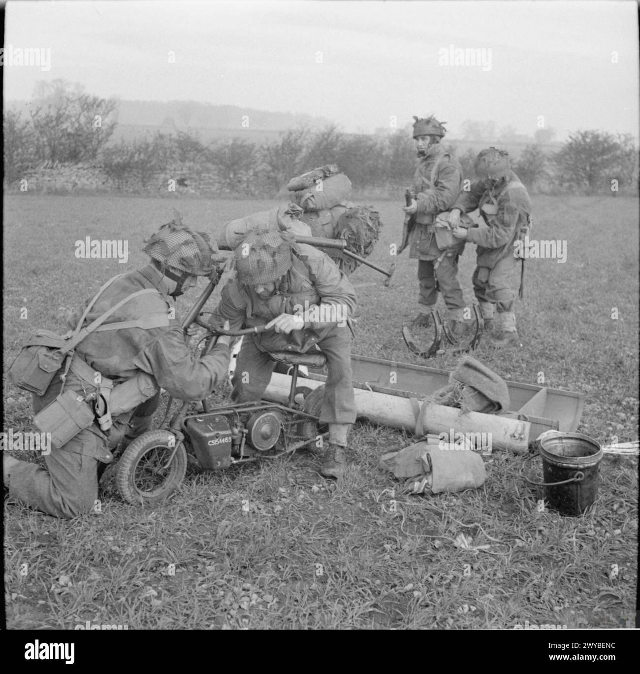 Fallschirmjäger holen ein Welbike-Faltmotorrad aus einem Ausrüstungscontainer in einer Abwurfzone während einer groß angelegten Flugübung am 22. April 1944 im Vereinigten Königreich. Stockfoto
