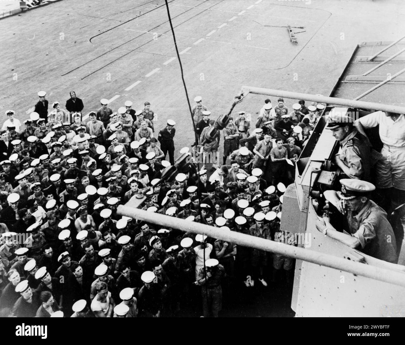 Am 8. Mai 1945 kündigt Captain G.R. Stokes, DSC, die deutsche Kapitulation an die auf dem Flugdeck der HMS Colossus versammelte Schiffsgesellschaft an. Stockfoto