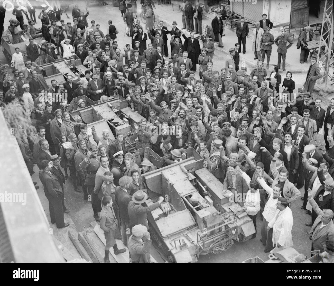 Während des Zweiten Weltkriegs wurde in Griechenland eine mechanisierte Militärsäule von Menschenmassen umgeben, während sie eine Stadt durchquerte. Stockfoto