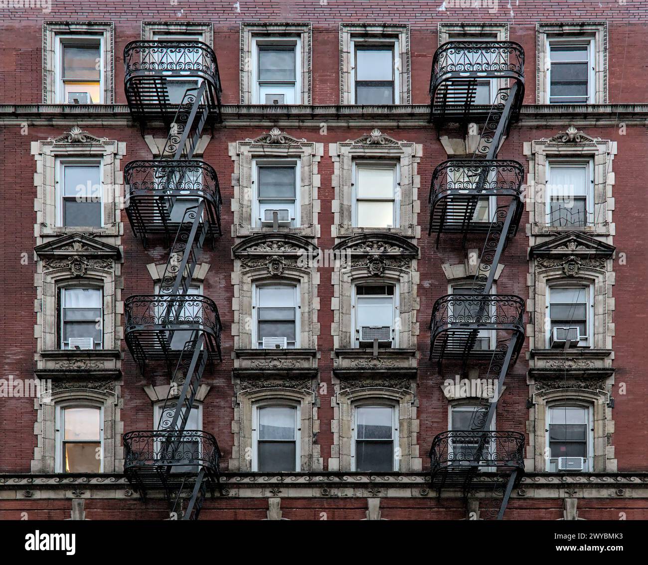 Typisches Wohngebäude auf der Lower East Side (Mietshaus mit Feuertreppe, Fenstern, Lampenpfosten) Detail (roter Backstein) Stockfoto