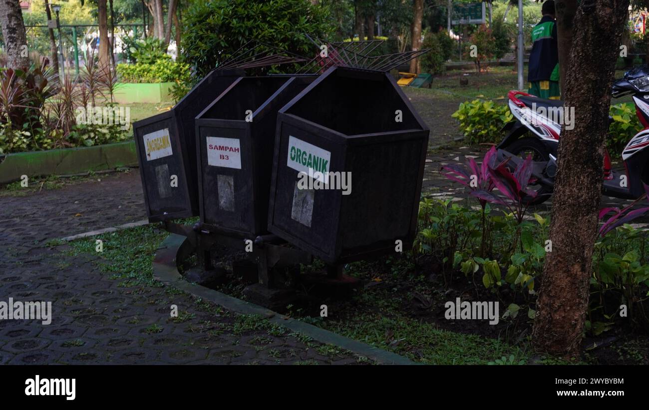 Ein rostiger Abfallbehälter in einem Park, der in drei Abfallkategorien unterteilt ist: Anorganischer Abfall, B3-Abfall und organischer Abfall Stockfoto