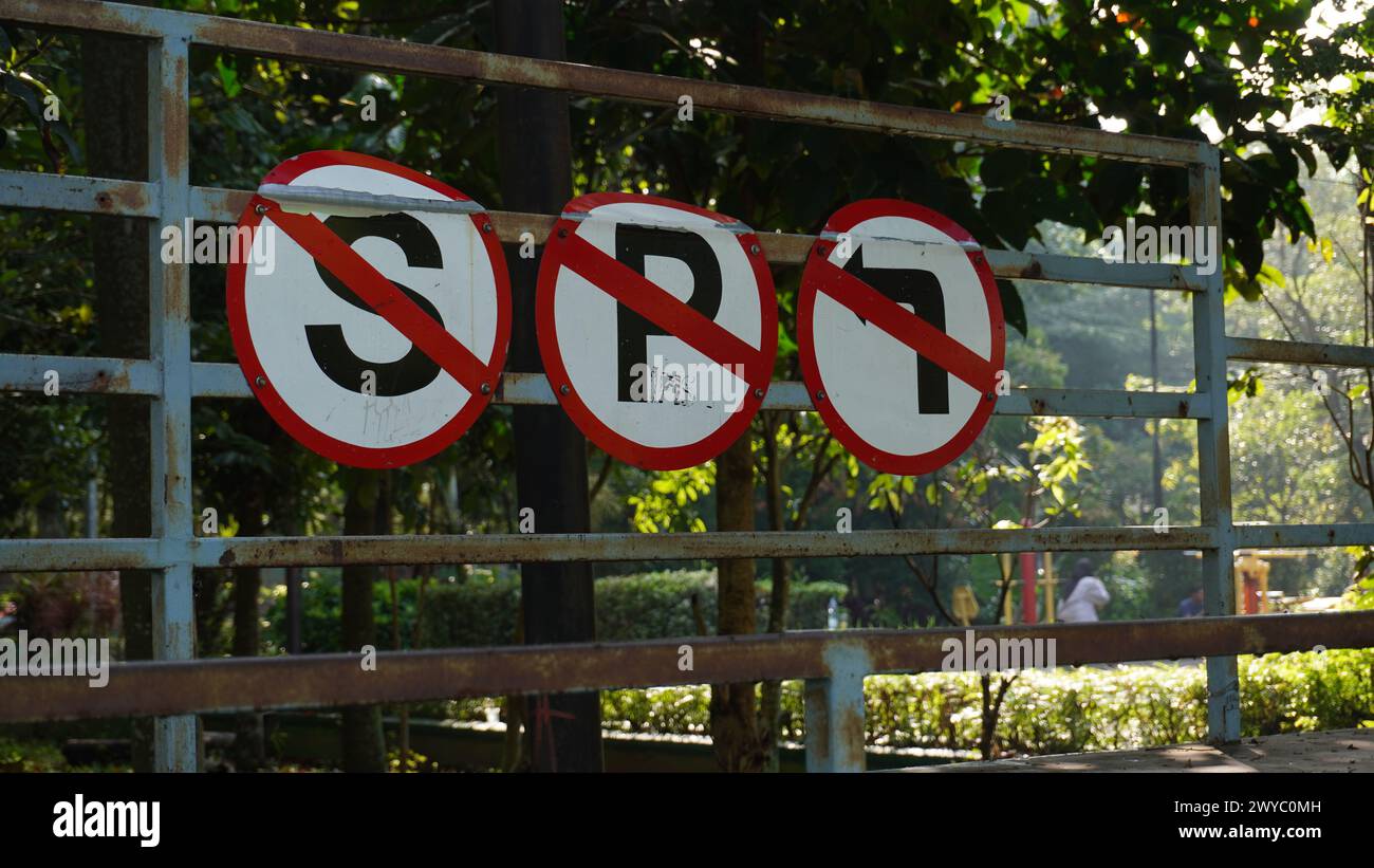 Schilder für das Anhalten, Parken und Linksabbiegen sind nebeneinander in einem Park angebracht, um Kinder über Verkehrsschilder zu informieren Stockfoto