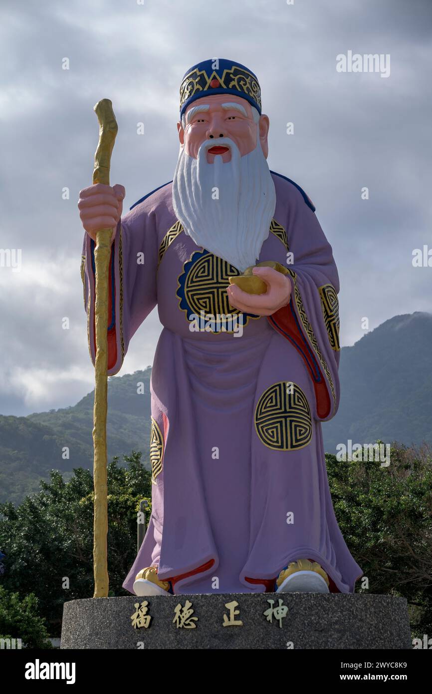 Eine majestätische Statue einer Gottheit steht hoch auf einem üppigen Berg Stockfoto Eine majestätische Statue einer Gottheit steht hoch auf einem üppigen Berg Stockfoto
