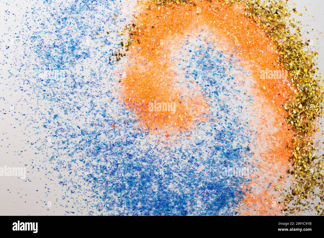 Bunte Glitzerpartikel aus Kunststoff auf weißem Hintergrund, weicher Fokus aus der Nähe Stockfoto