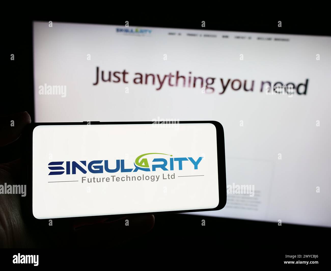 Person mit Smartphone und Logo der Firma Singularity Future Technology Ltd. Vor der Website. Schwerpunkt auf dem Display des Telefons. Stockfoto