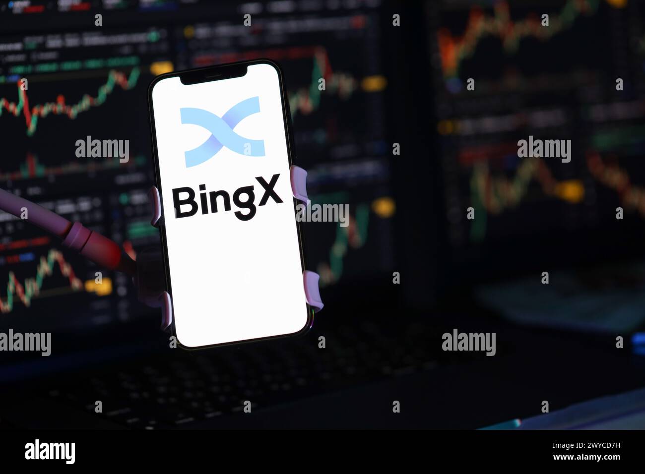 KIEW, UKRAINE - 15. MÄRZ 2024 BingX-Logo auf dem iPhone-Display und Kryptowährungswertdiagrammen. Portal für den Austausch von Kryptowährungen Stockfoto