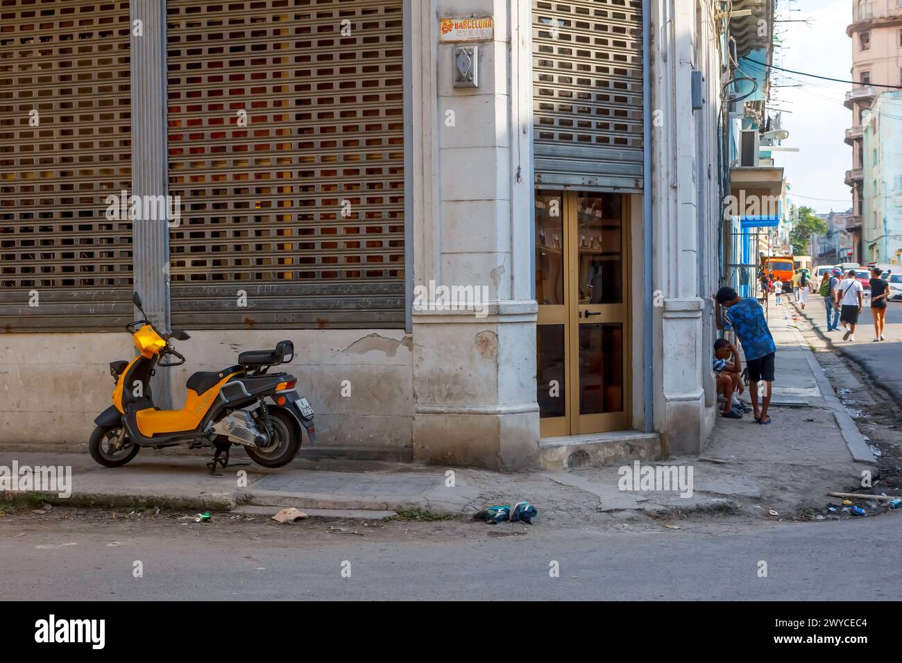 Elektro- oder E-Bike auf einem beschädigten Gehweg bei einem verwitterten Fassadengebäude in Havanna, Kuba Stockfoto