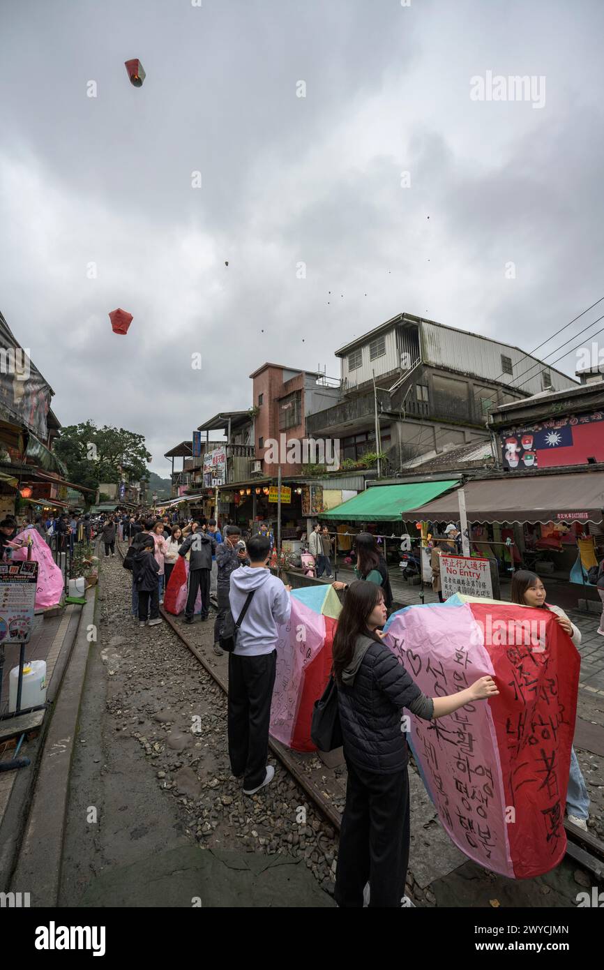 Touristen und Zuschauer beteiligen sich an der Veröffentlichung von Laternen, um sich auf den Bahngleisen in Shifen Wünsche für das neue Jahr zu machen Stockfoto