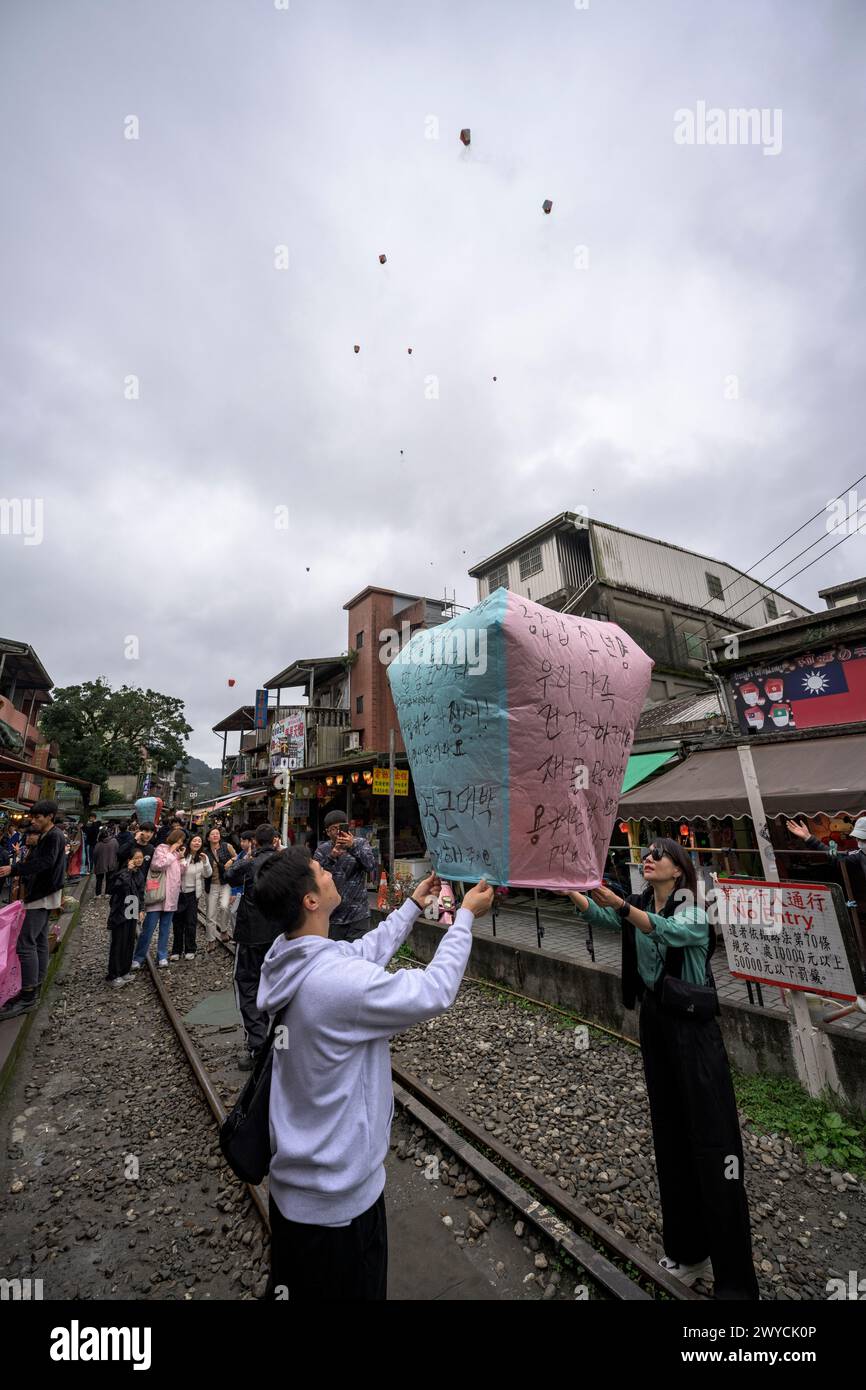 Touristen und Zuschauer beteiligen sich an der Veröffentlichung von Laternen, um sich auf den Bahngleisen in Shifen Wünsche für das neue Jahr zu machen Stockfoto